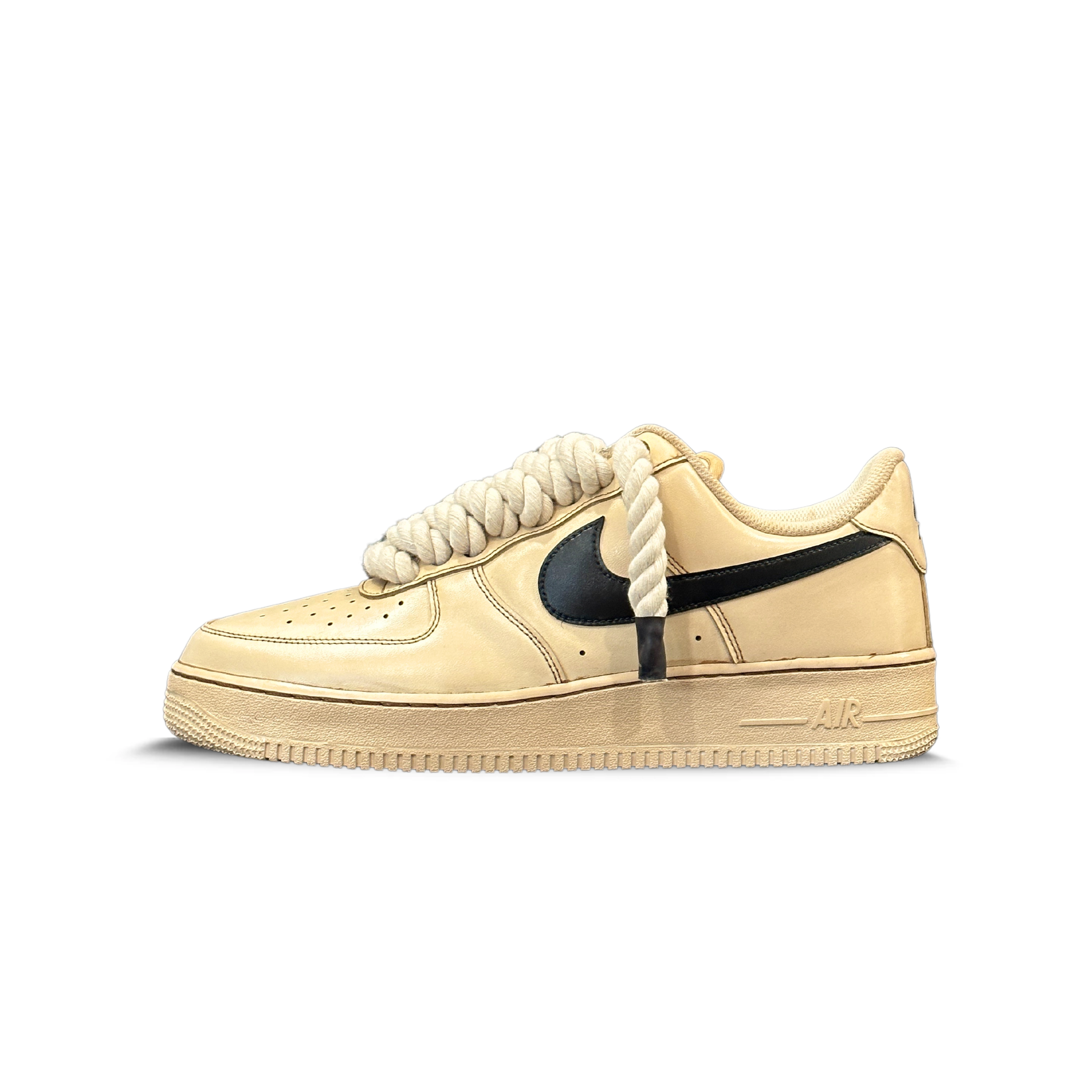 Beige low-top sneaker with black swoosh and thick rope laces on white background