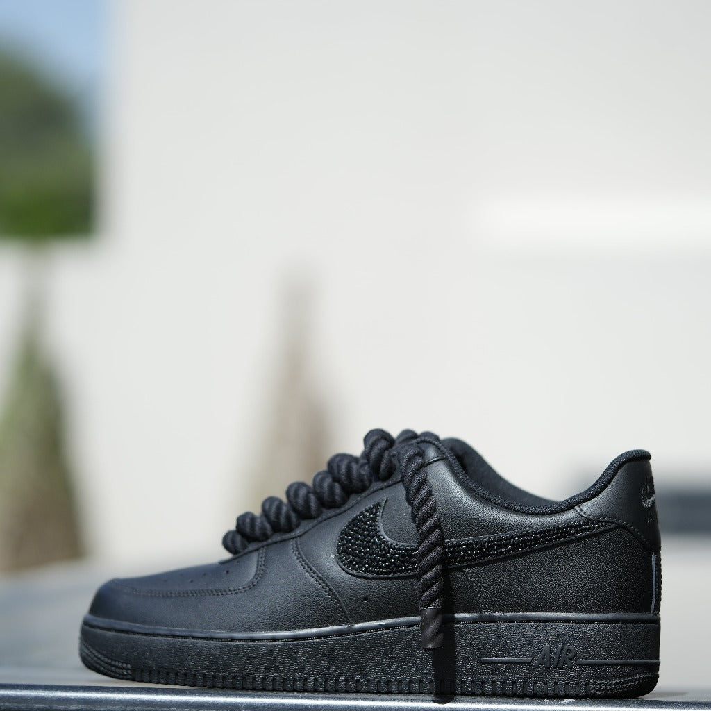 Black Nike Air Force 1 sneaker with textured Swoosh and thick laces, streetwear style