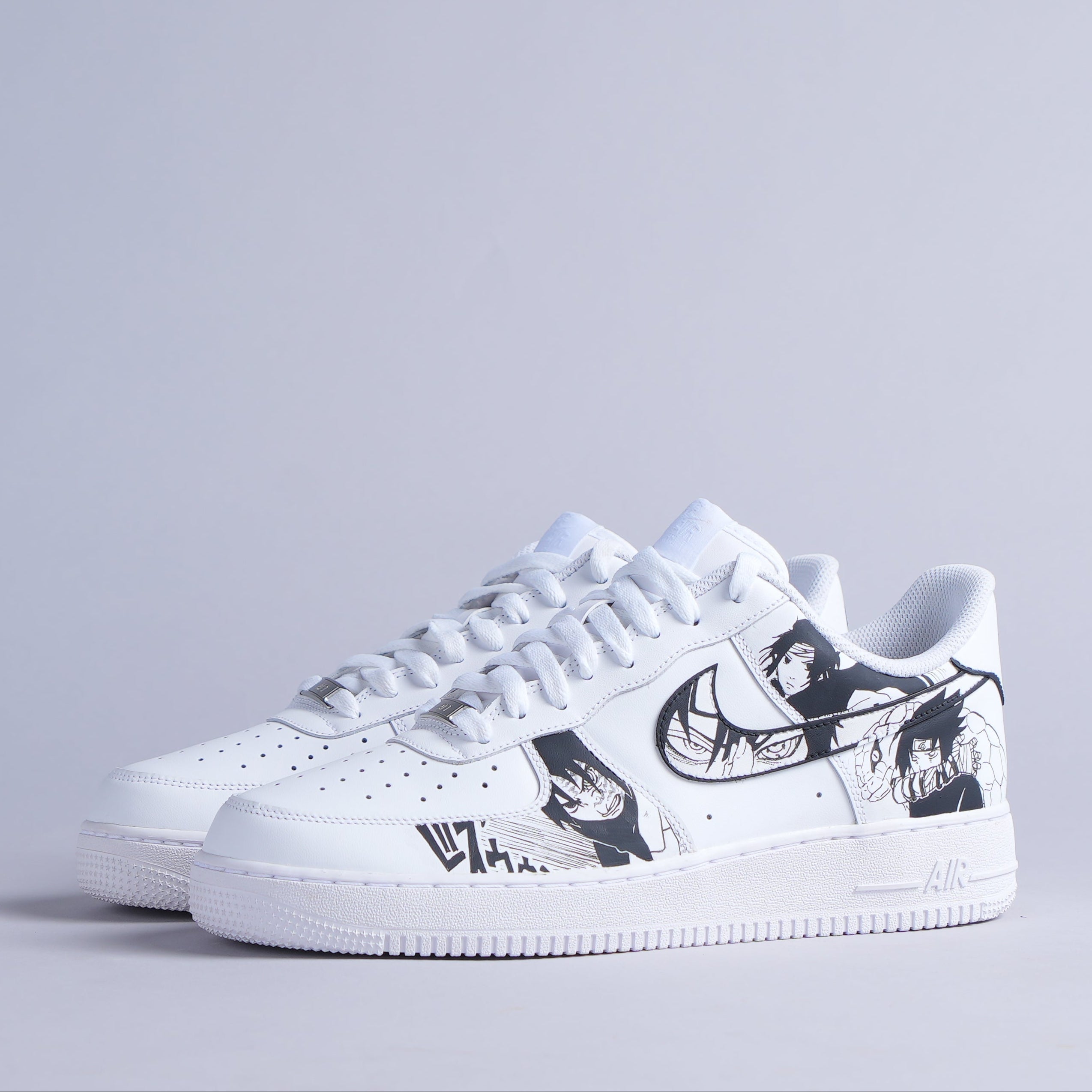 White streetwear sneakers with black anime-inspired graphic print, side view, on plain background