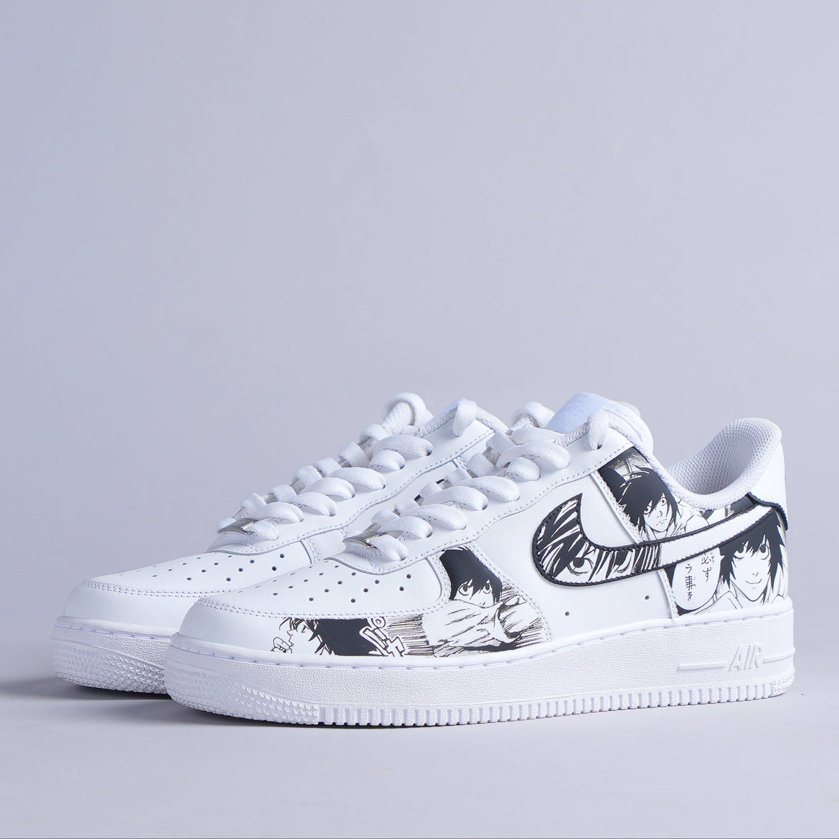 White sneakers with black anime graphic design on side, streetwear footwear on gray background