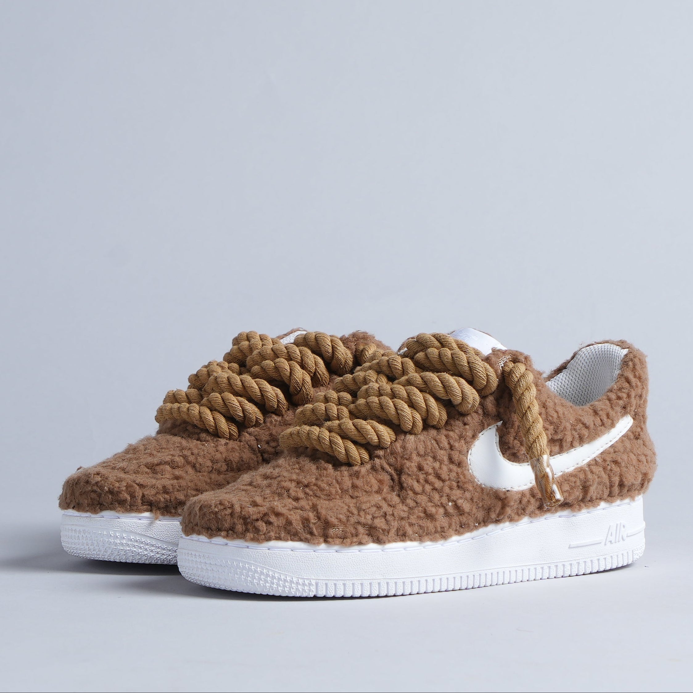 Brown fuzzy streetwear sneakers with thick rope laces and white Nike swoosh on white sole