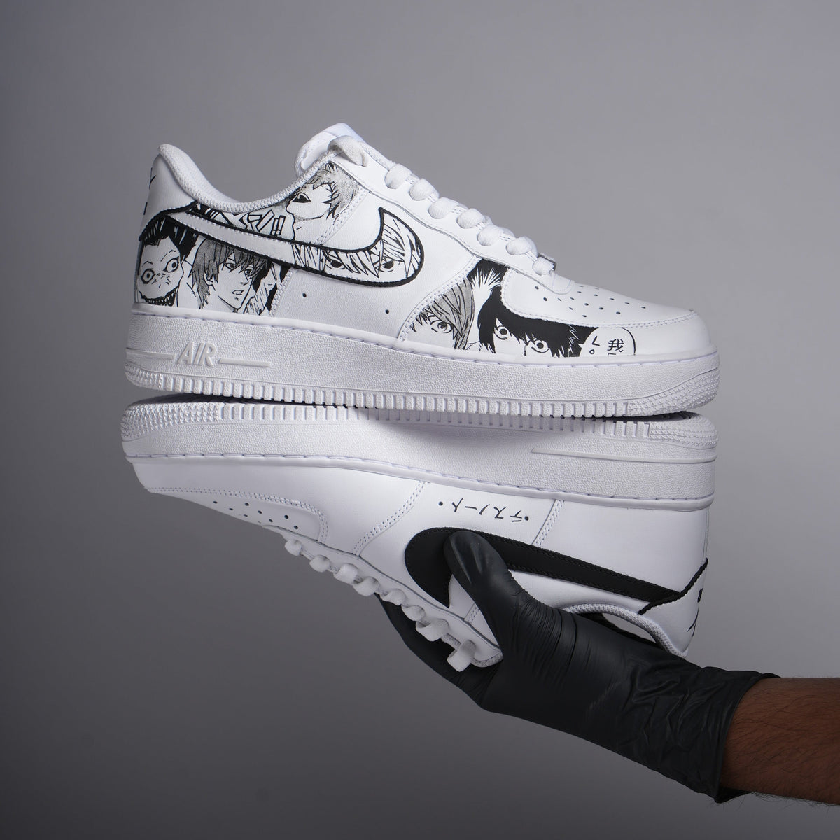 White custom sneakers with black anime character illustrations and bold swoosh design