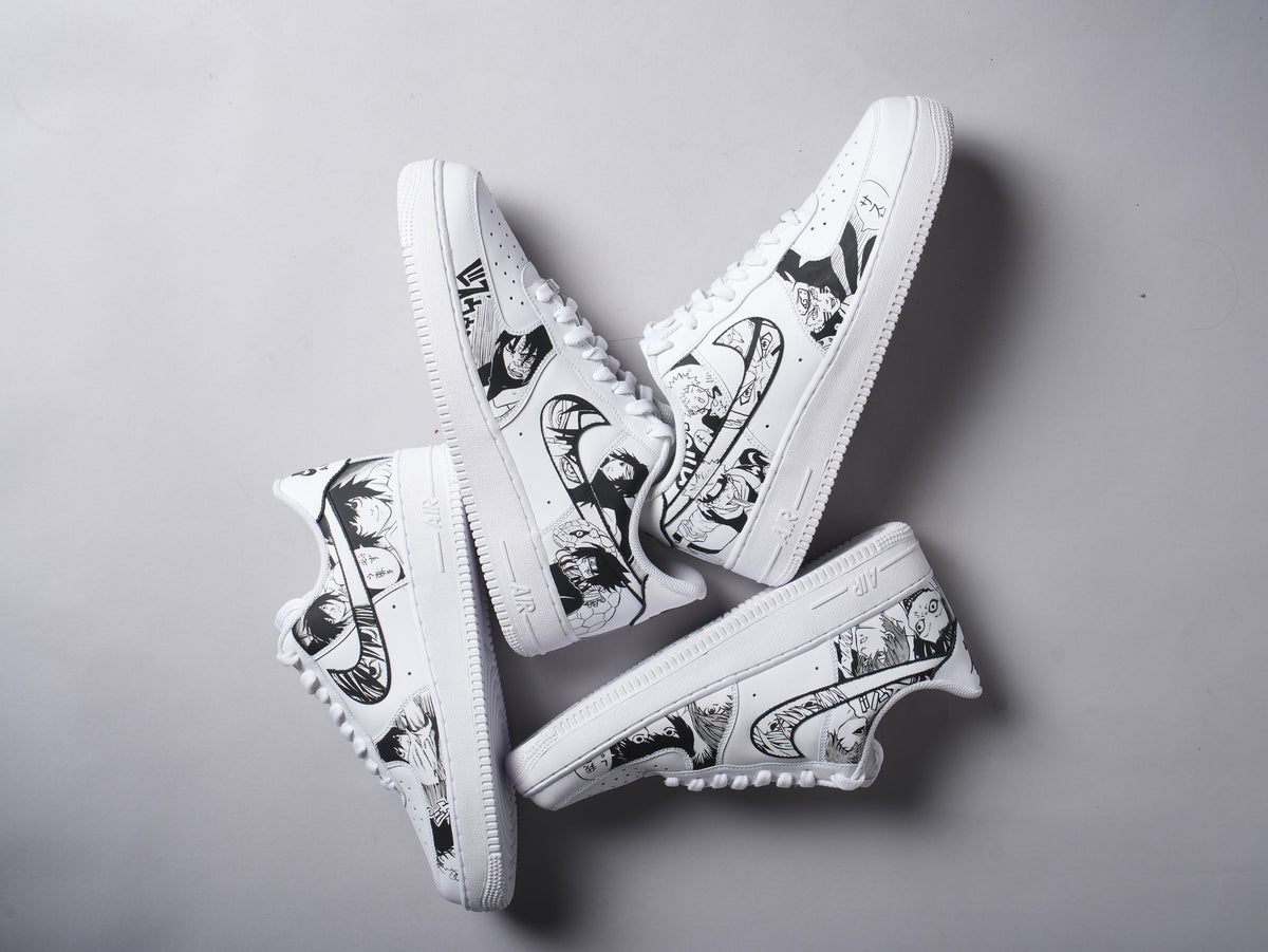 White custom sneakers with black anime-inspired graphic designs on sides, streetwear style