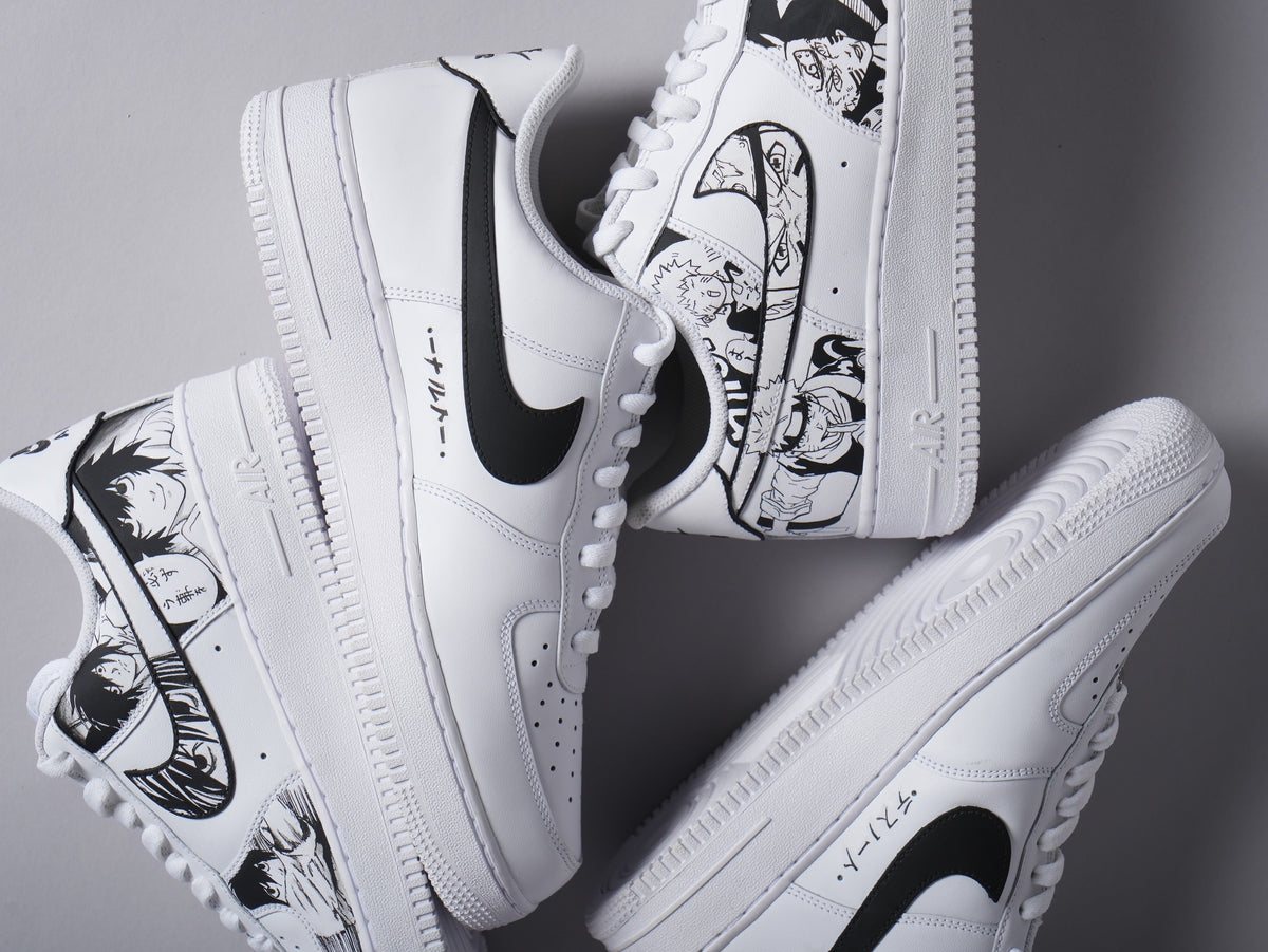 White Nike Air Force 1 sneakers with black anime-inspired illustrations and Japanese text