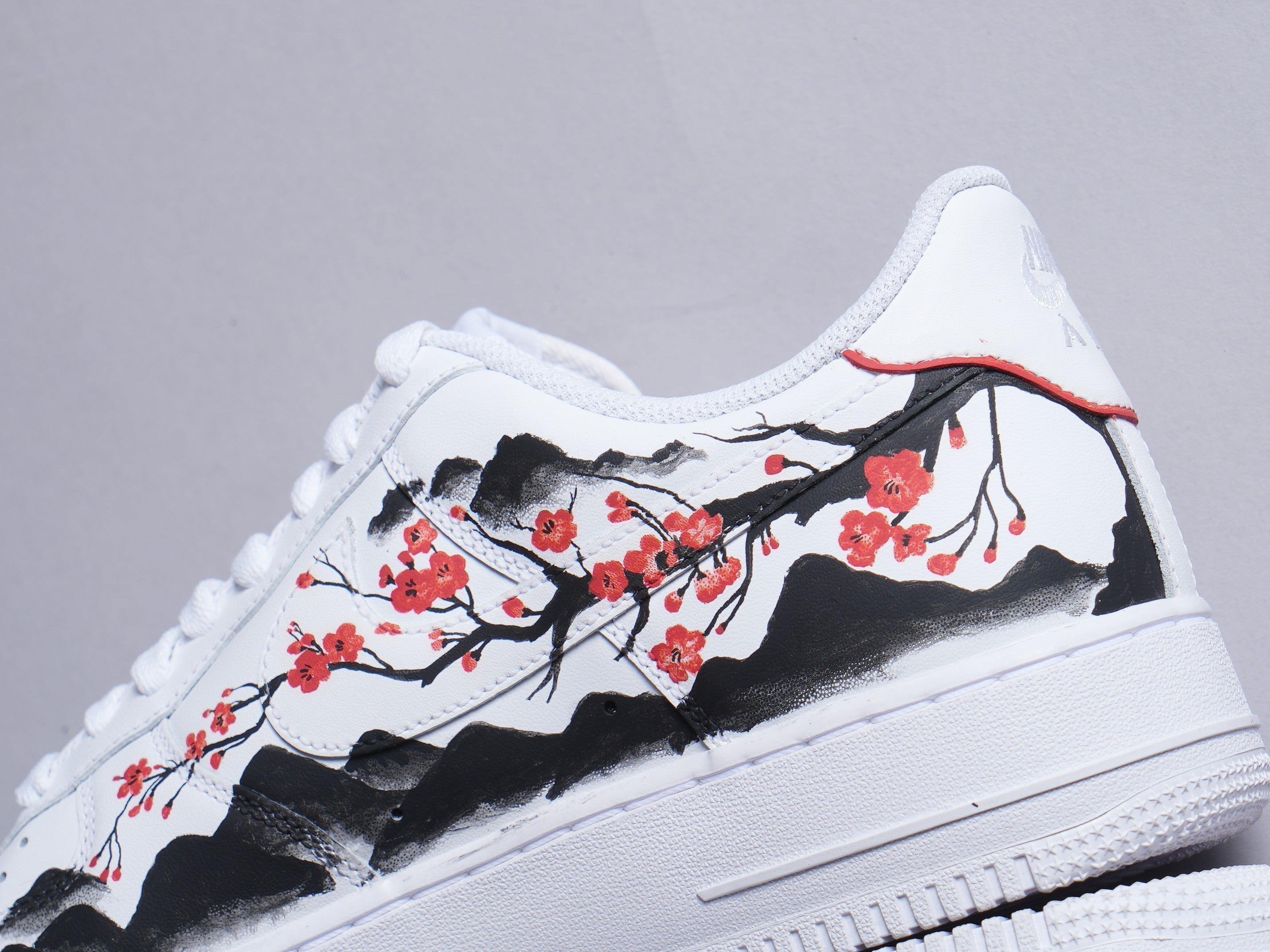 White sneaker with hand-painted cherry blossoms and black mountain design, streetwear style