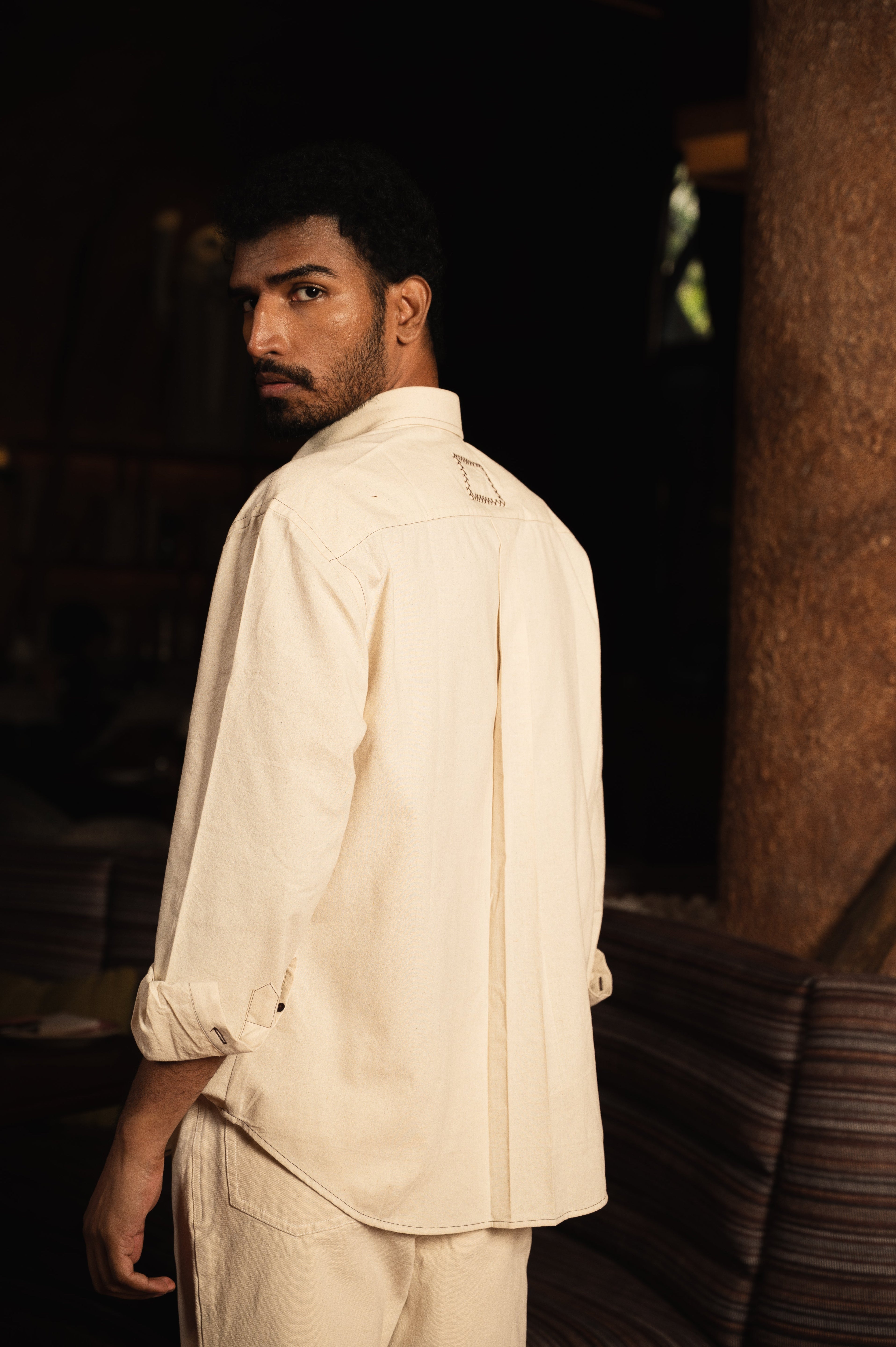 Man wearing cream long sleeve shirt and pants, streetwear fashion indoors