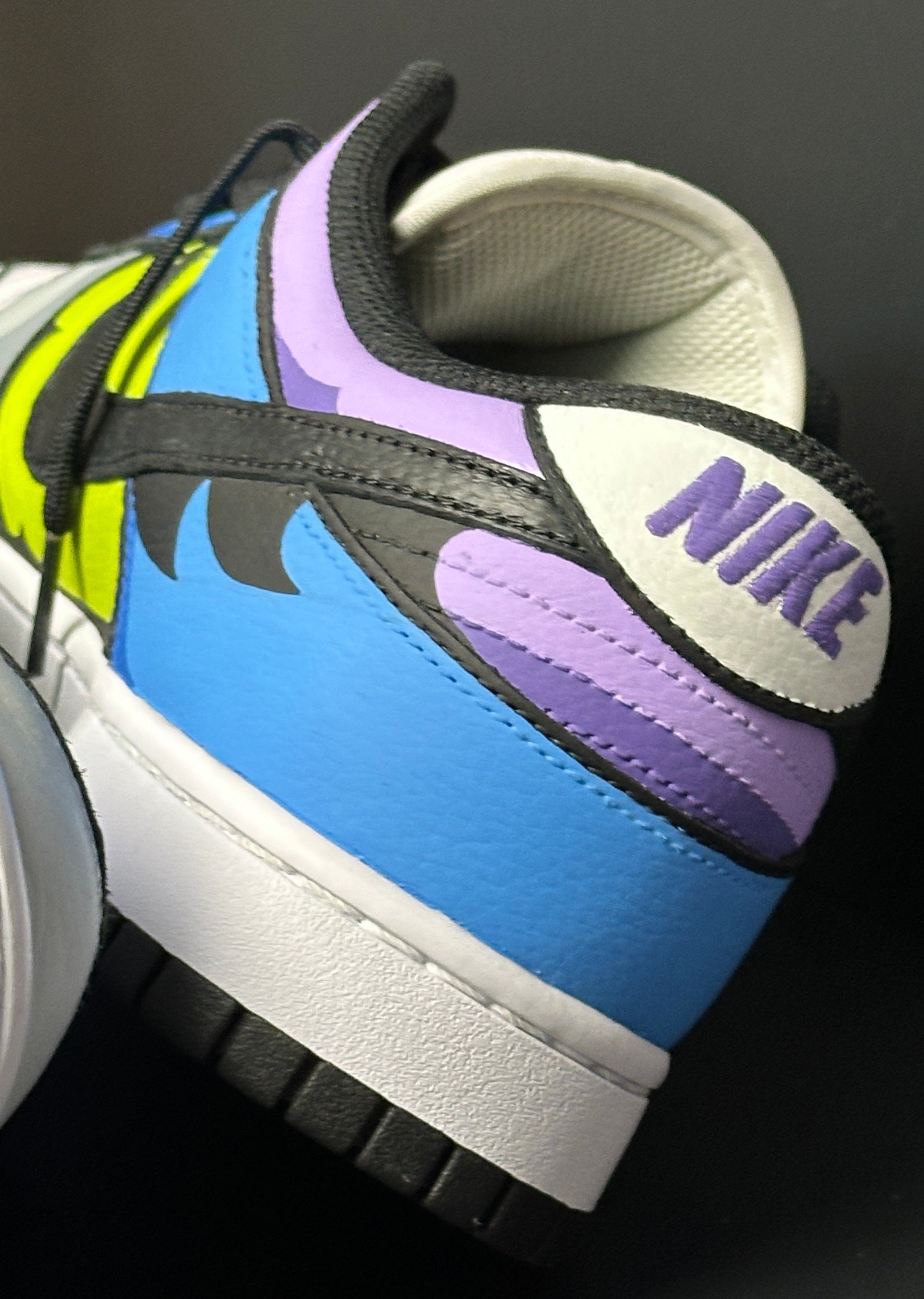 Colorful Nike sneaker with blue, purple, yellow, and black details on a white sole
