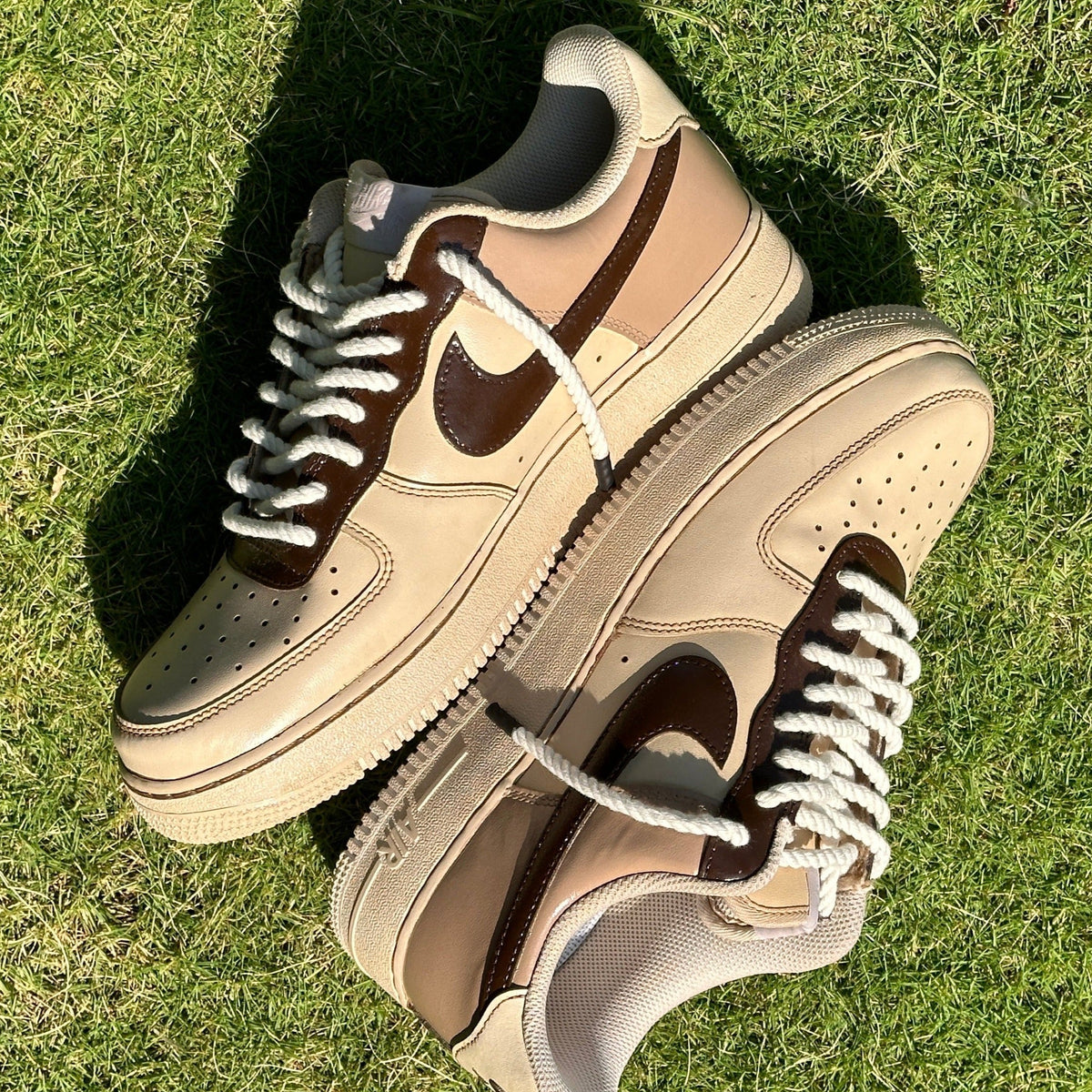 Beige and brown leather streetwear sneakers with thick laces on green grass