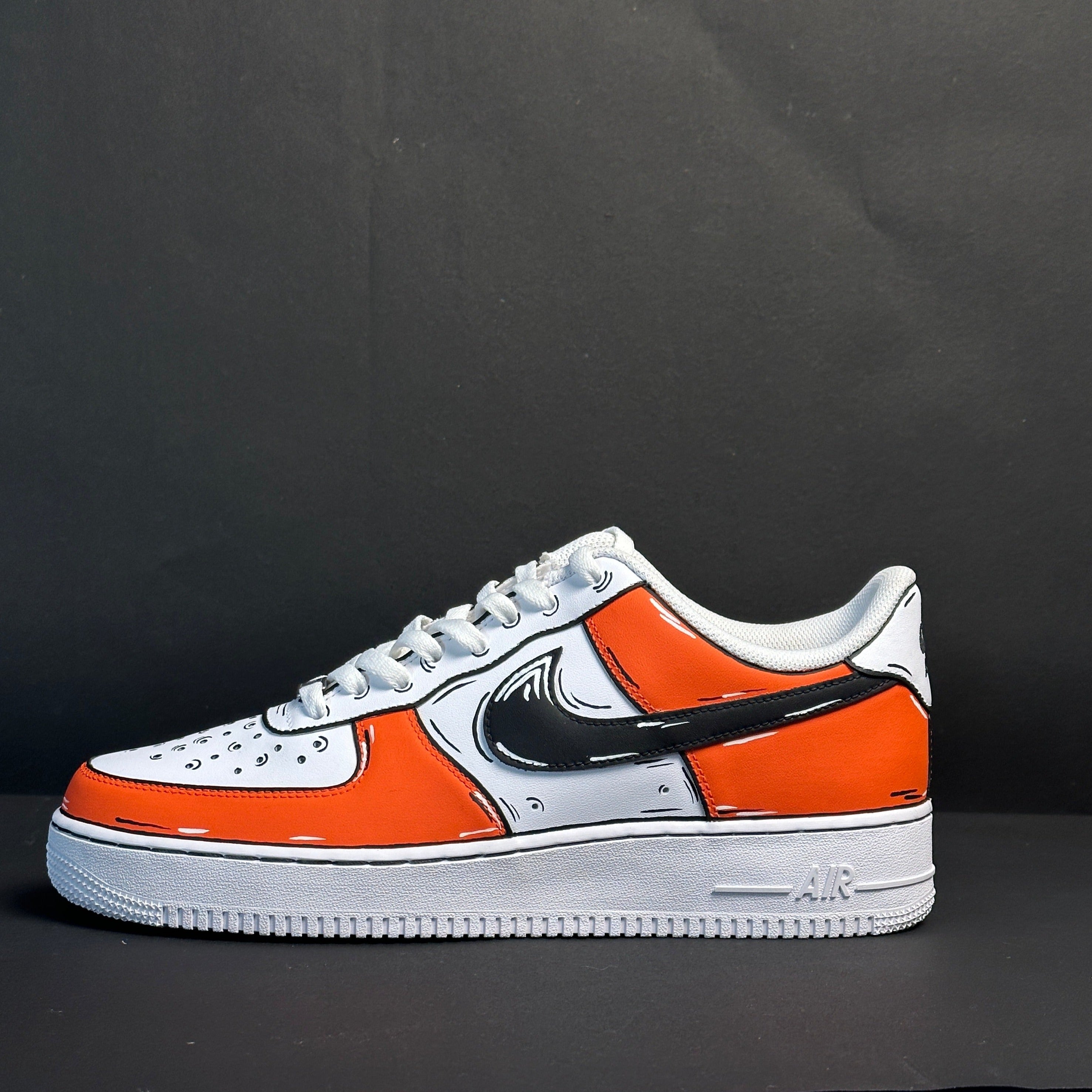 White and orange streetwear sneaker with black outlined details on a dark background
