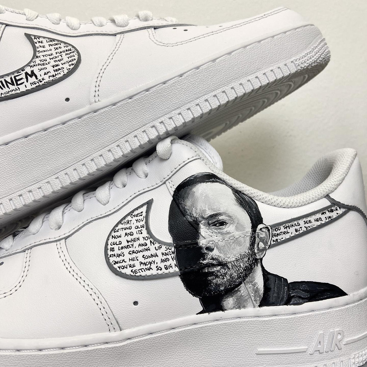 Custom white Air Force 1 sneaker with hand-painted portrait and handwritten lyrics on the side.