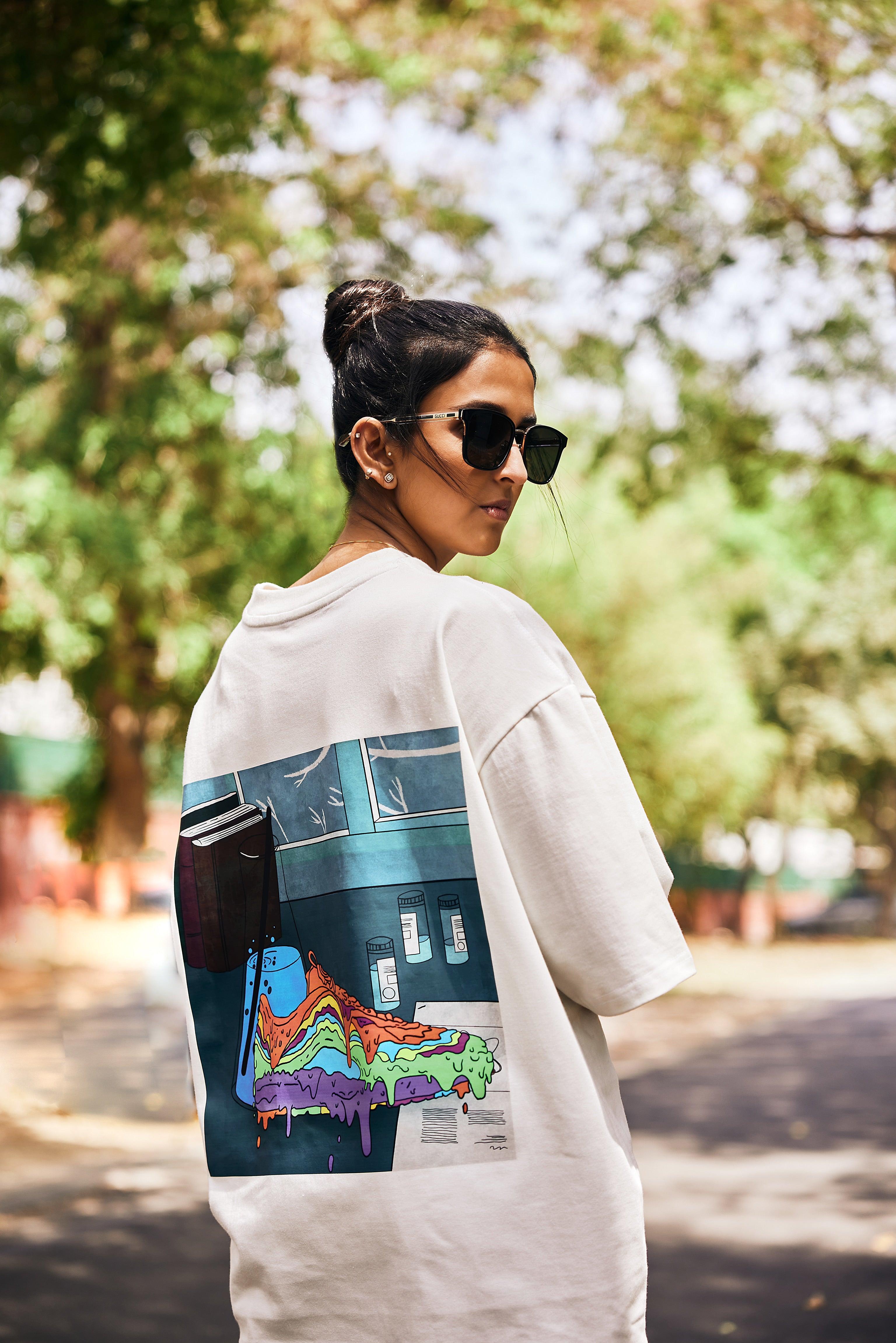 Woman wearing oversized streetwear t-shirt with colorful sneaker graphic, outdoors