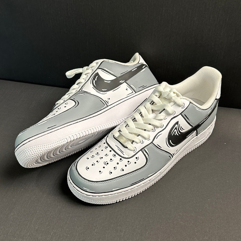 White and grey custom cartoon-style Nike Air Force 1 sneakers with black details on a dark background