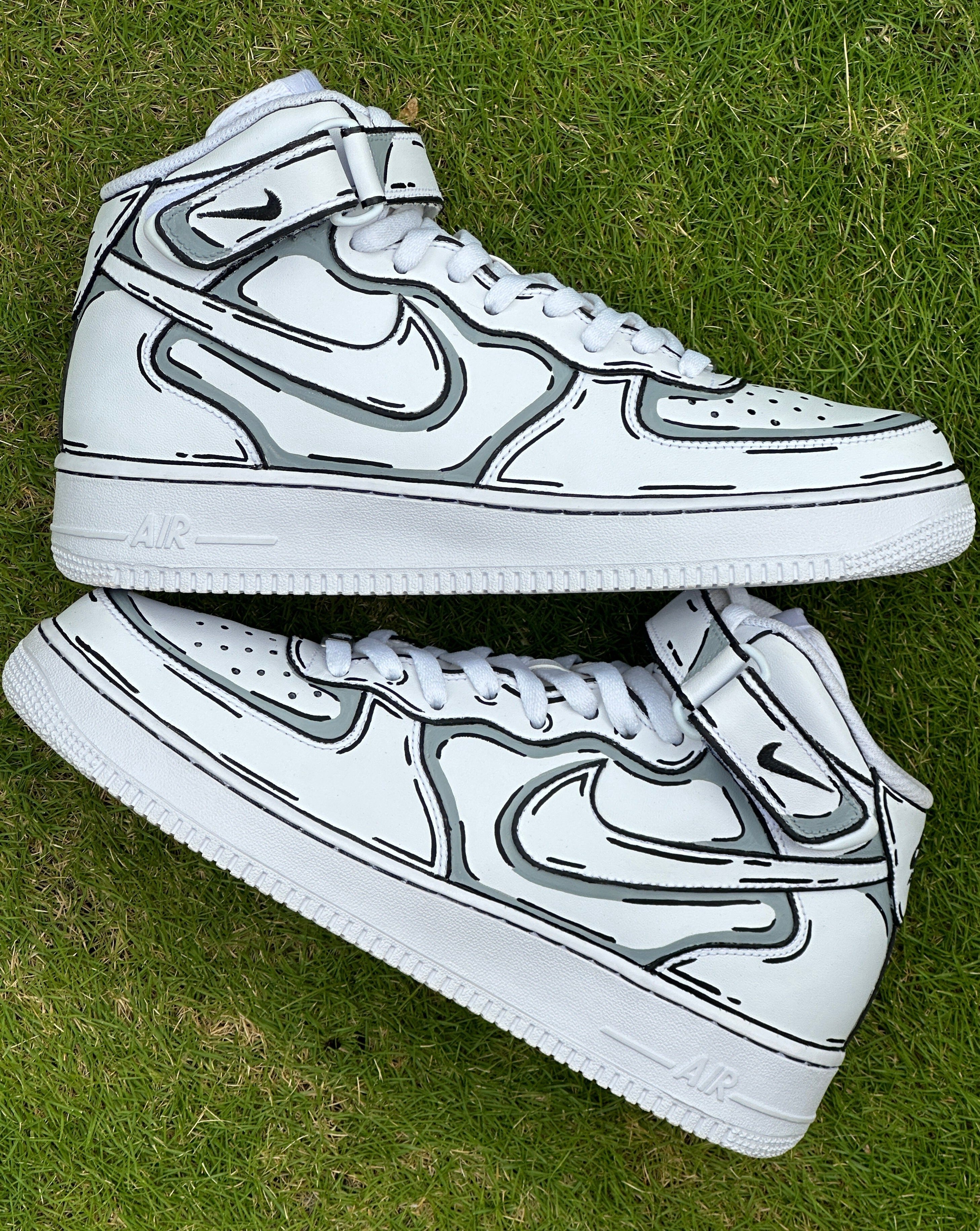 White high-top sneakers with black outline design on grass, streetwear style shoes
