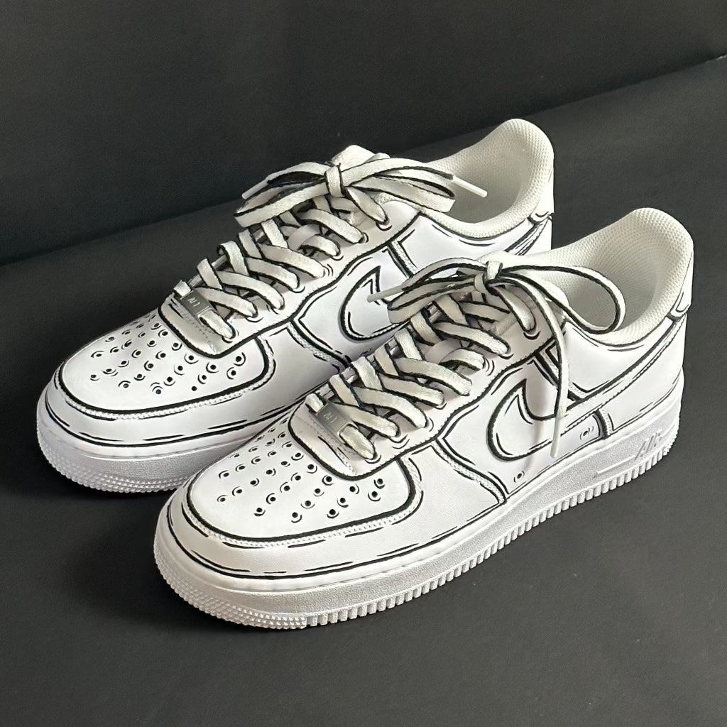 White streetwear sneakers with black outline details on a dark background
