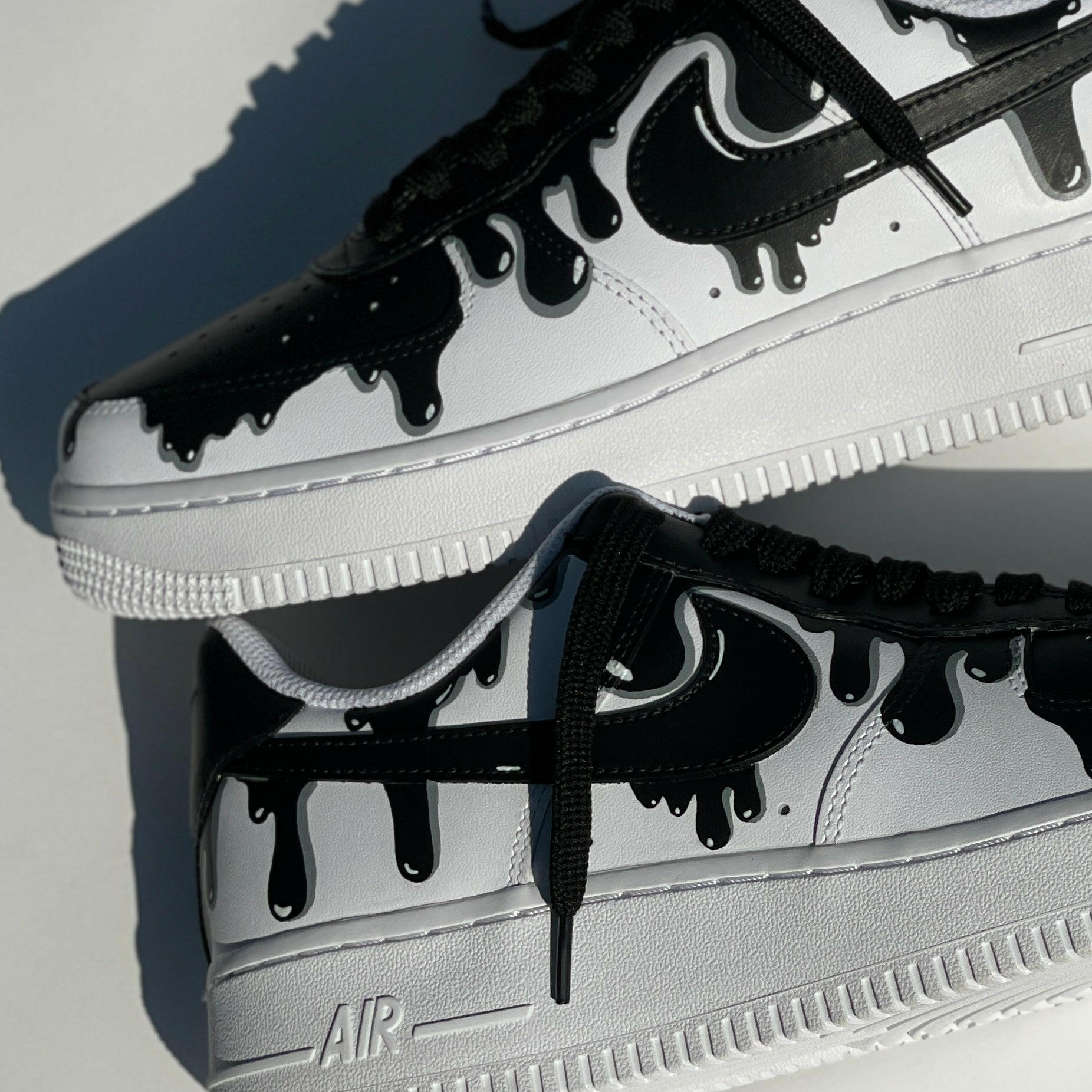 Black and white streetwear sneakers with drip design and bold graphic details
