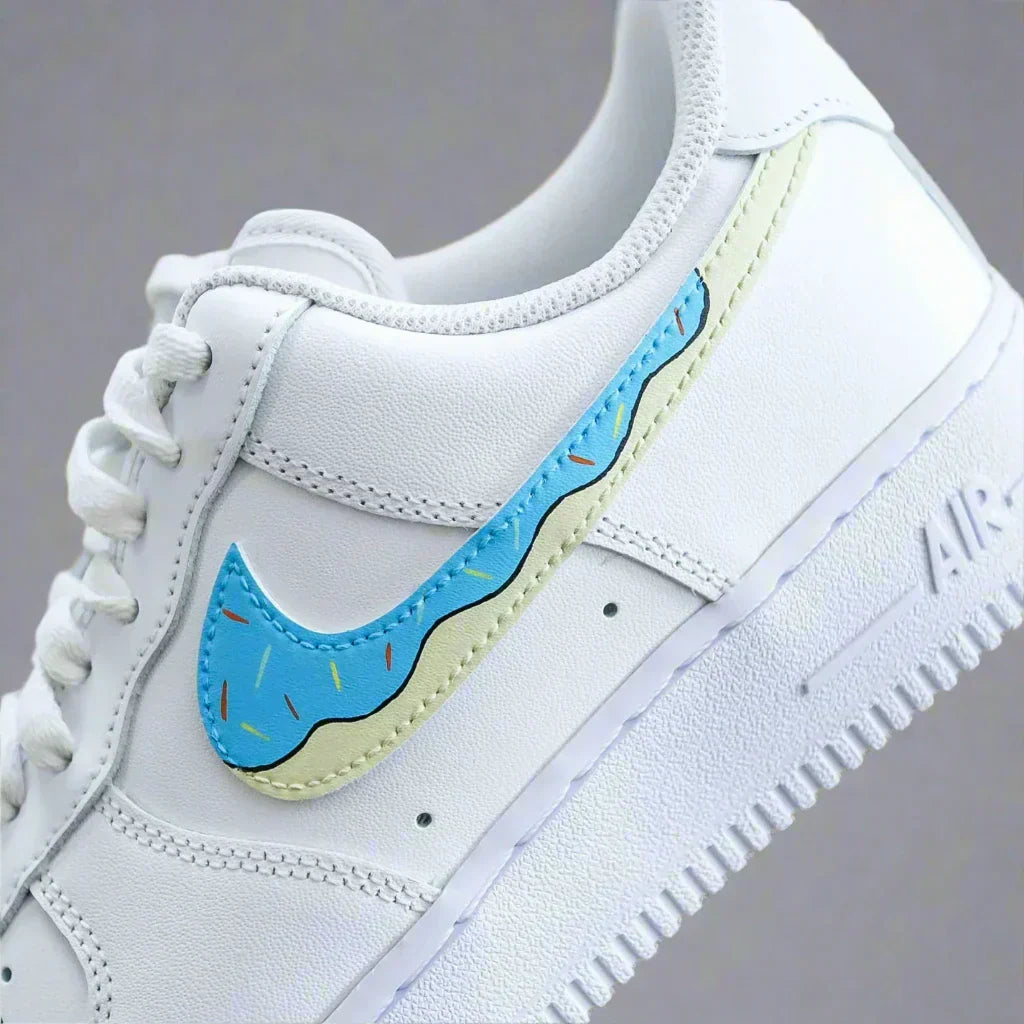 White sneaker with blue and yellow swoosh featuring sprinkle details, streetwear style