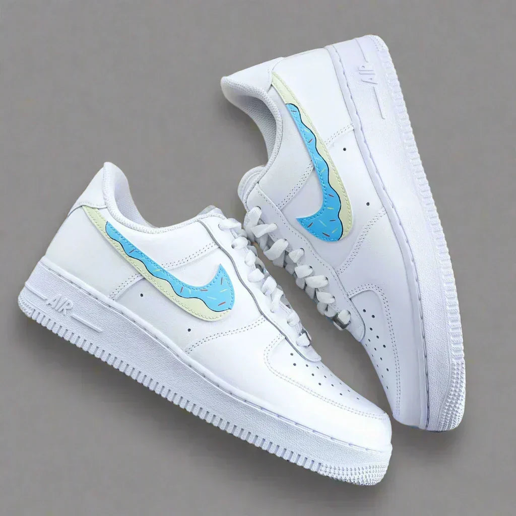 White low-top sneakers with unique blue and cream swoosh, streetwear style, on grey background