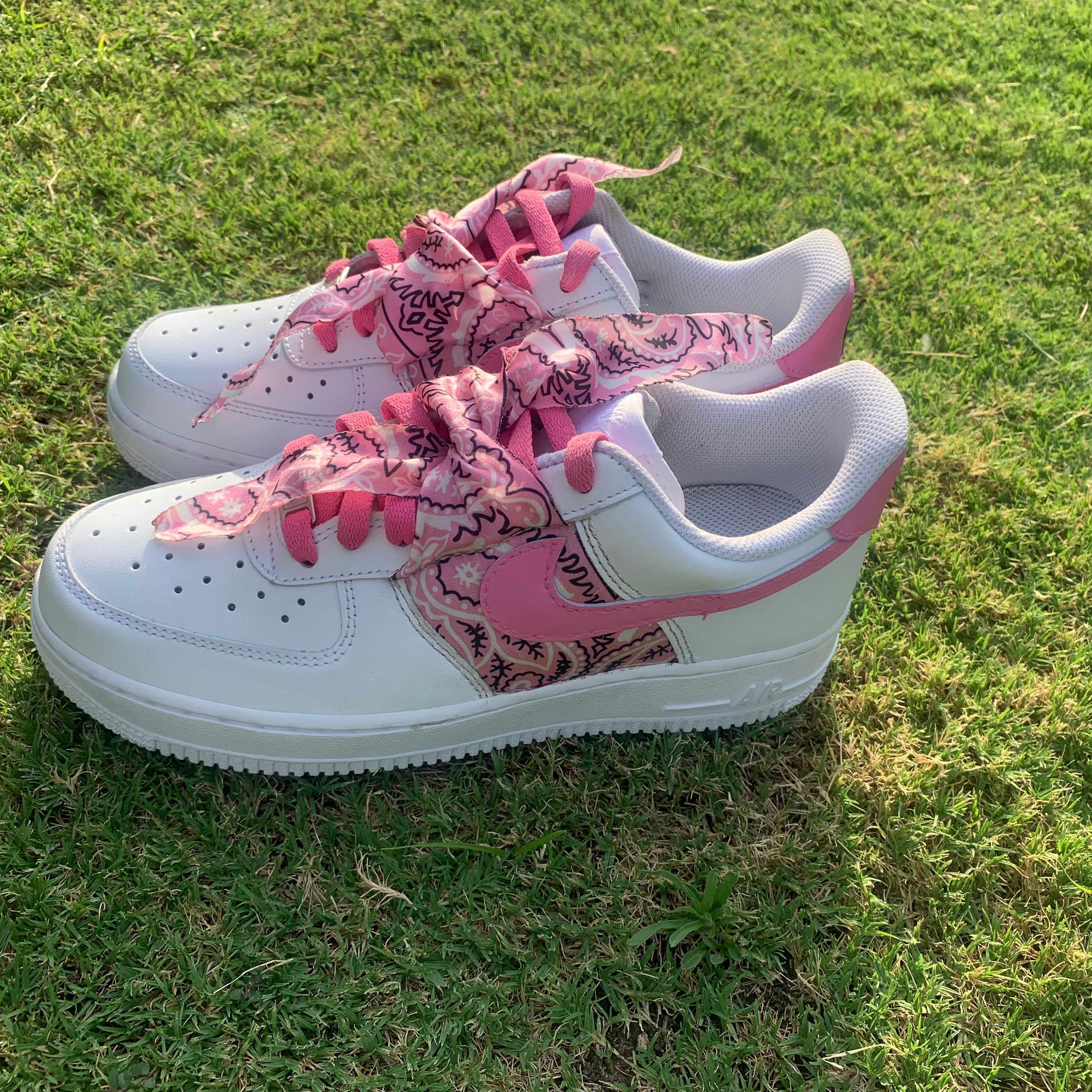 White and pink streetwear sneakers with paisley laces on grass