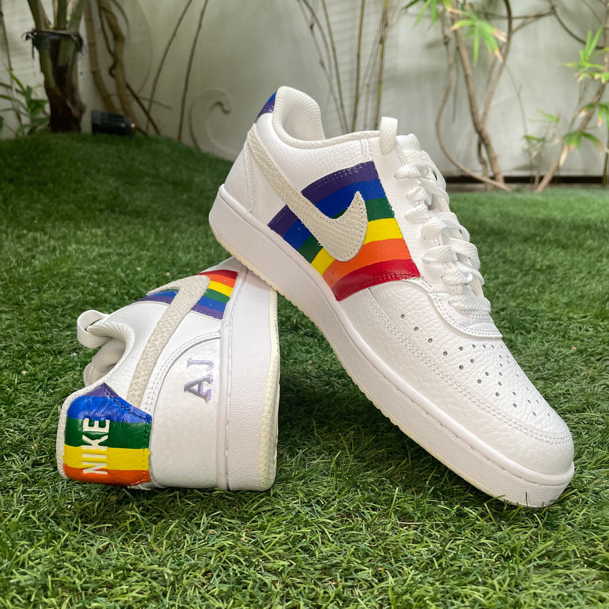 White Nike sneakers with rainbow accents on grass, streetwear and limited edition style