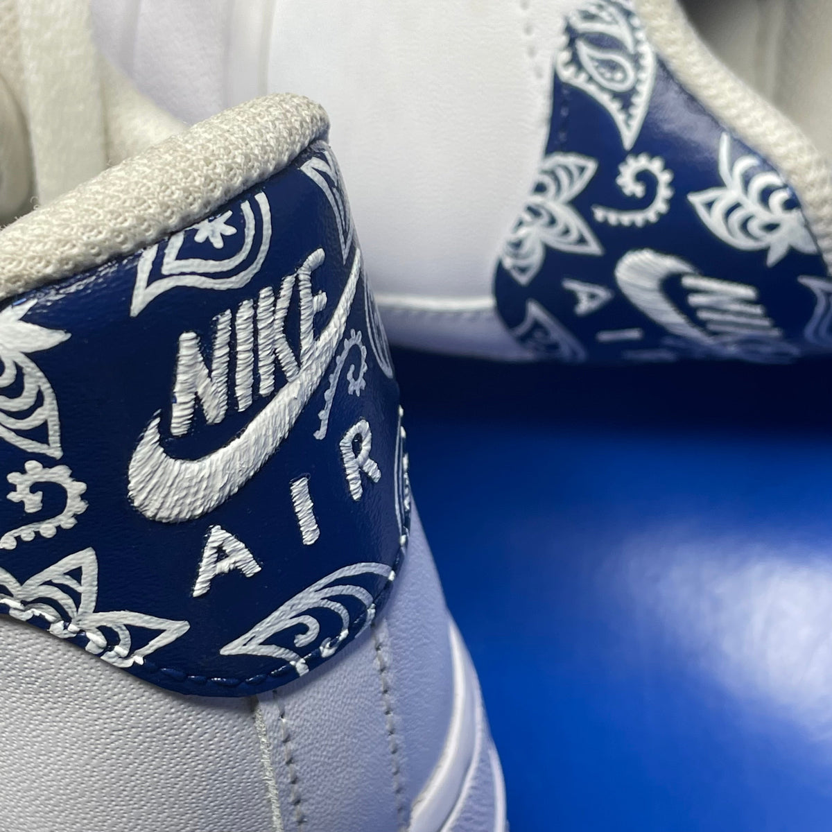 Closeup of Nike Air white sneaker heel with blue paisley bandana print detail on leather