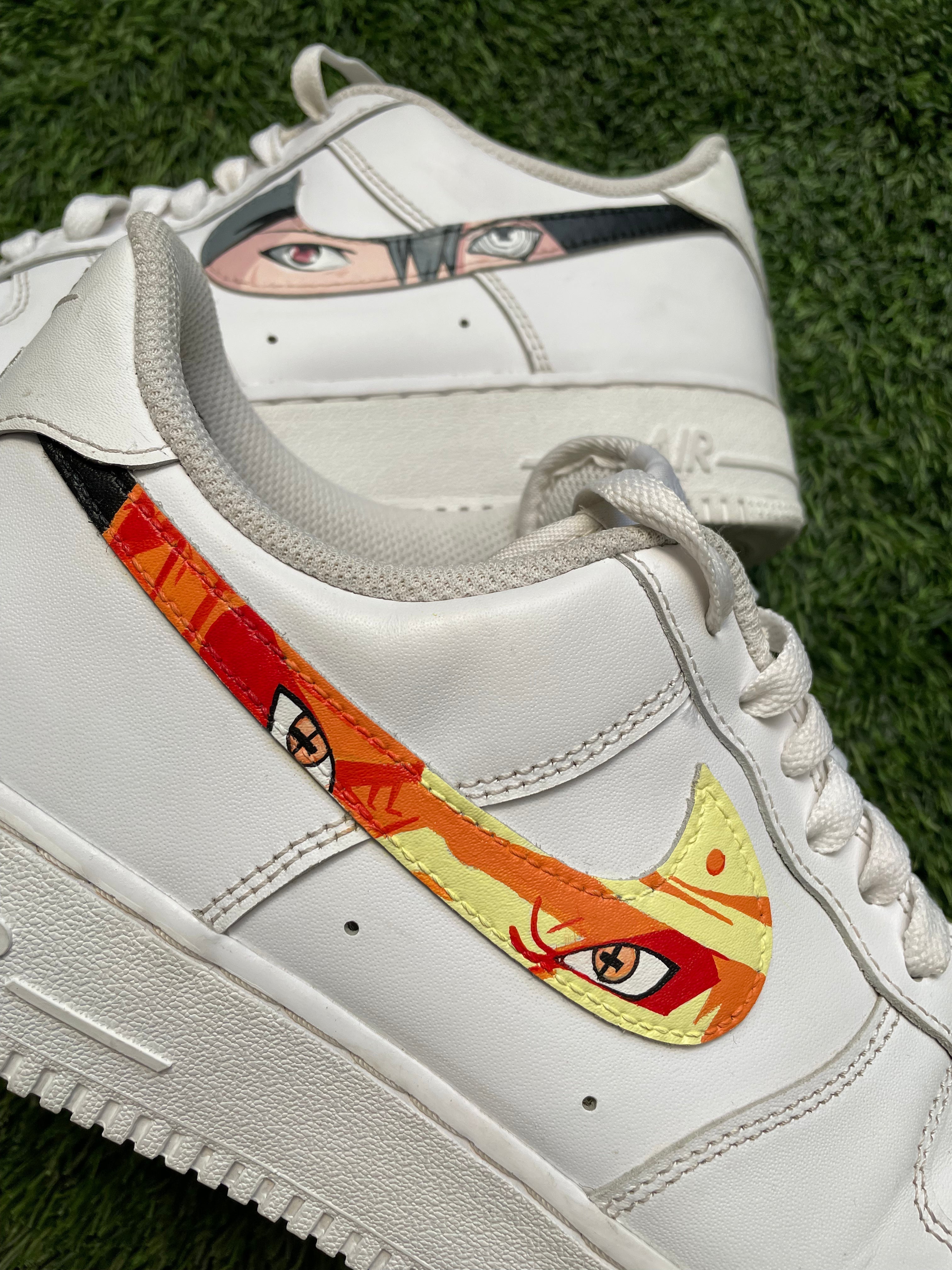 Custom white sneakers with anime-inspired eye designs and colorful Swoosh on green grass