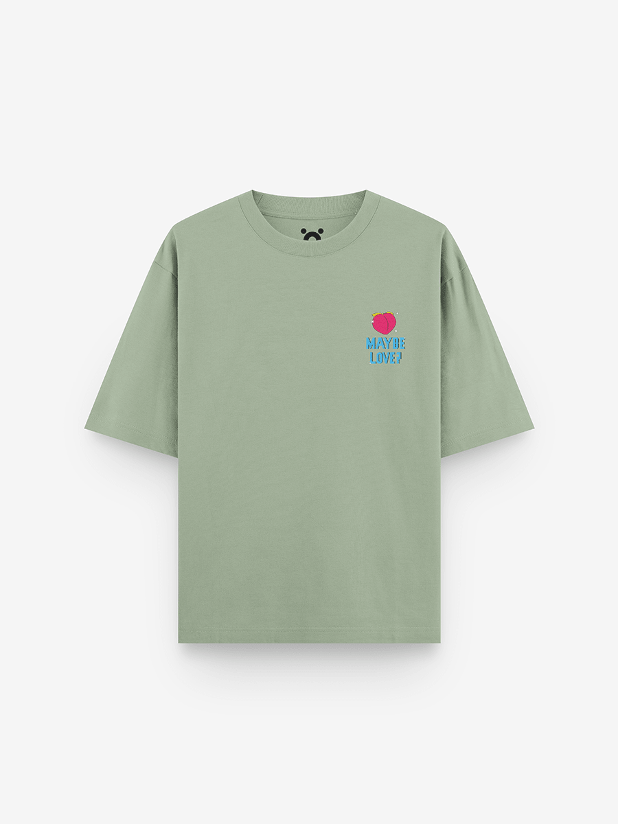 Sage green streetwear t-shirt with small pink heart and 'Maybe Love?' blue text on chest