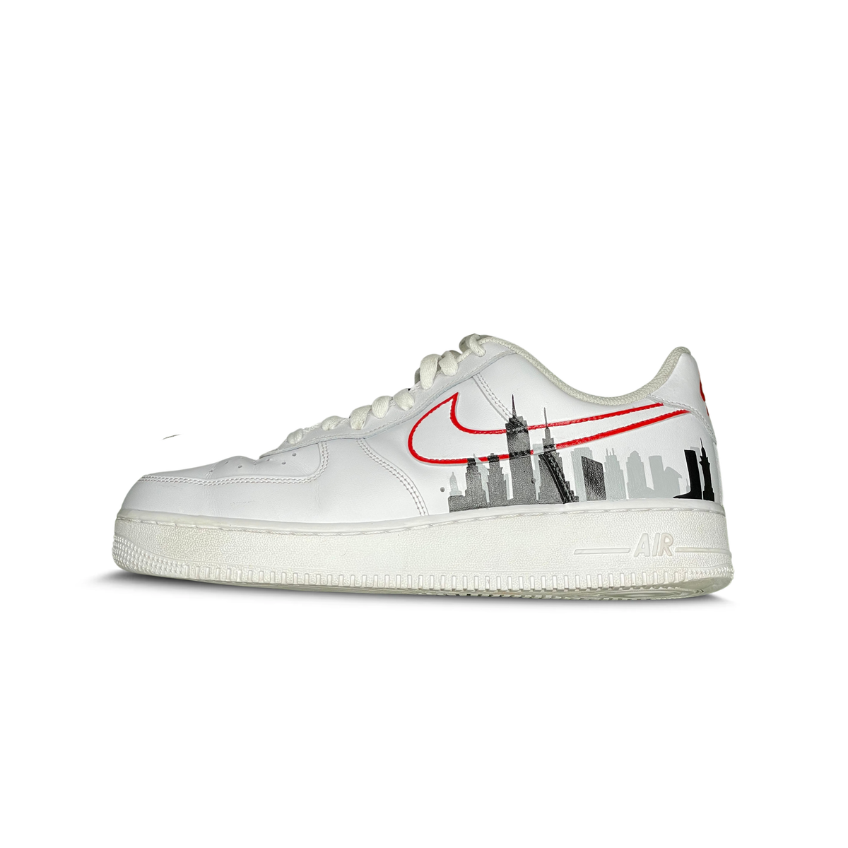 White sneaker with New York City skyline graphic and red outlined Swoosh logo on the side