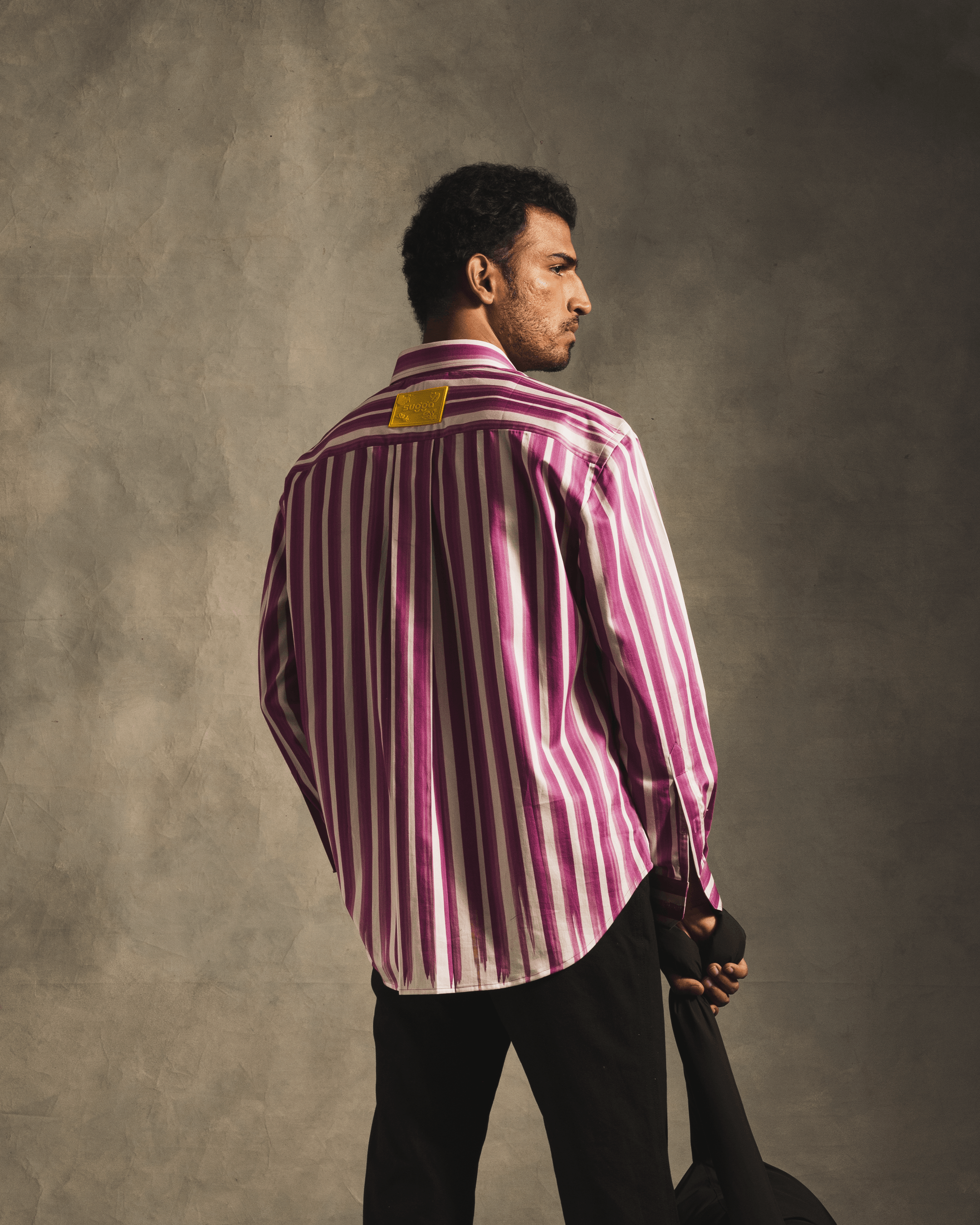 Man wearing pink and white vertical striped shirt, streetwear fashion, neutral background