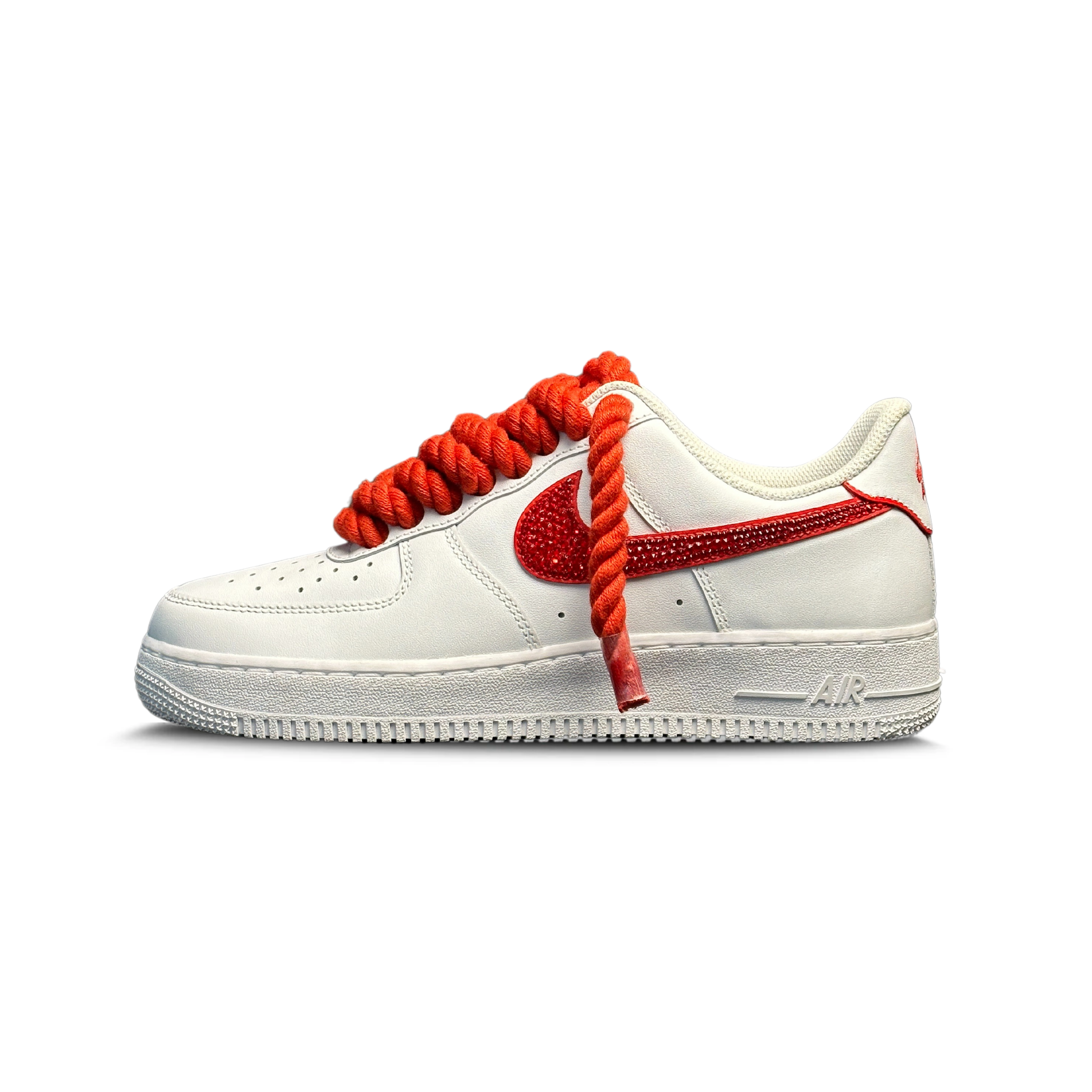 White sneaker with oversized red rope laces and red jeweled Swoosh on a clean background