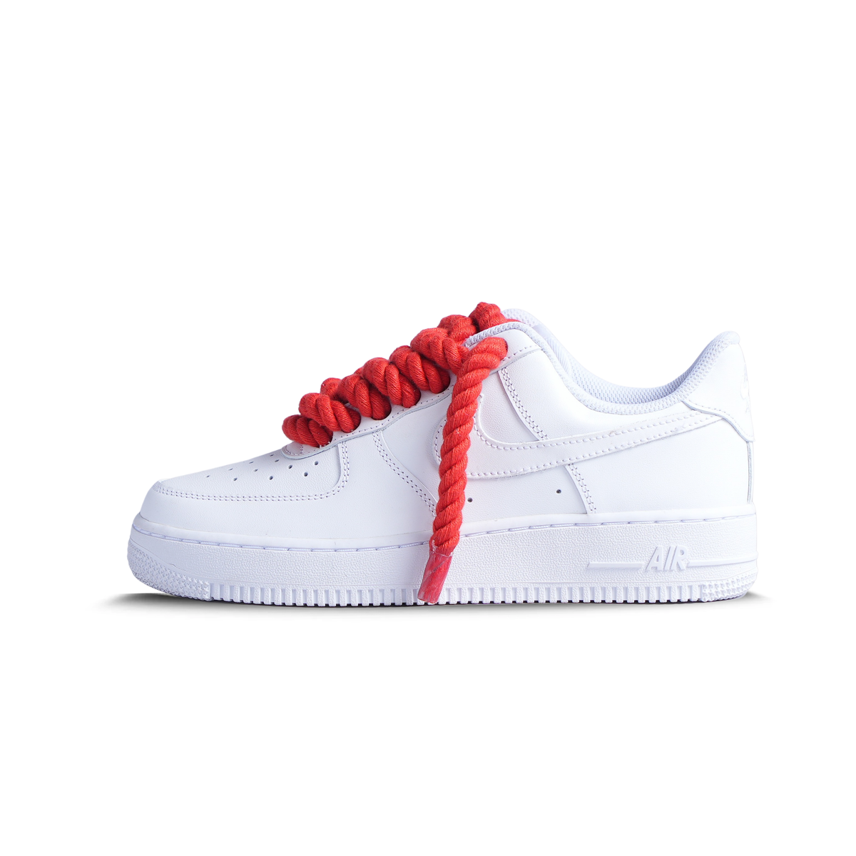 White low-top sneaker with oversized red rope laces, streetwear footwear on white background.