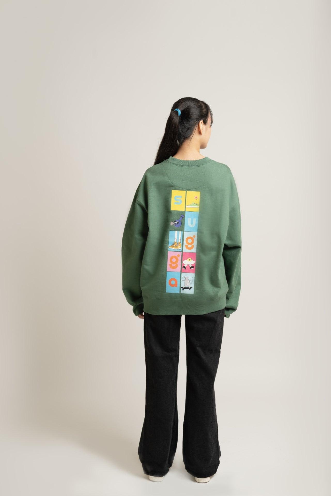 Woman wearing green streetwear sweatshirt with colorful graphic blocks on the back