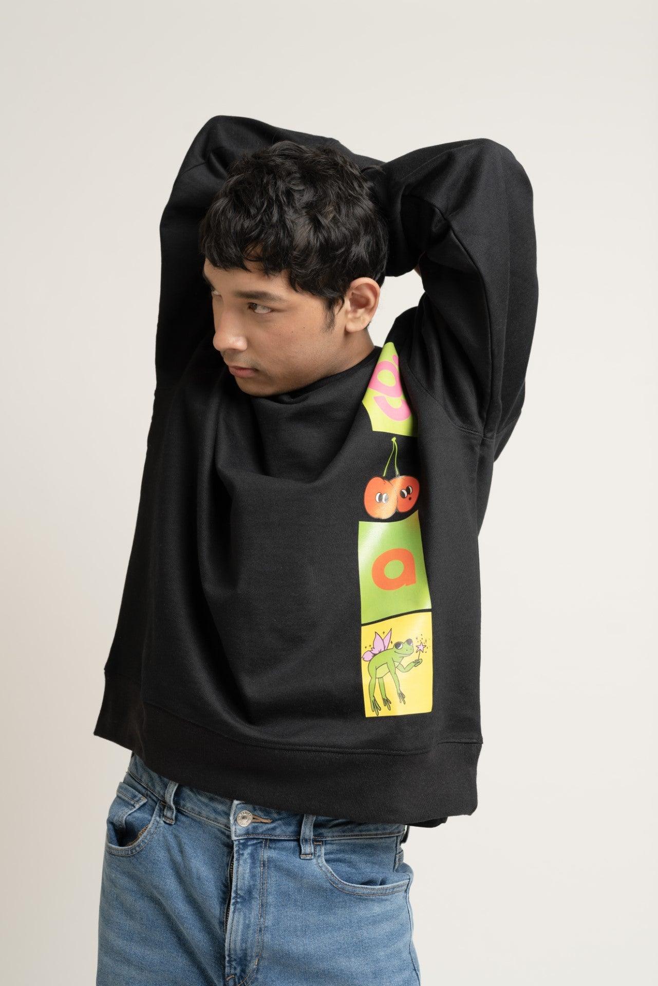 Man wearing black streetwear sweatshirt with colorful graphic print, blue jeans, neutral background