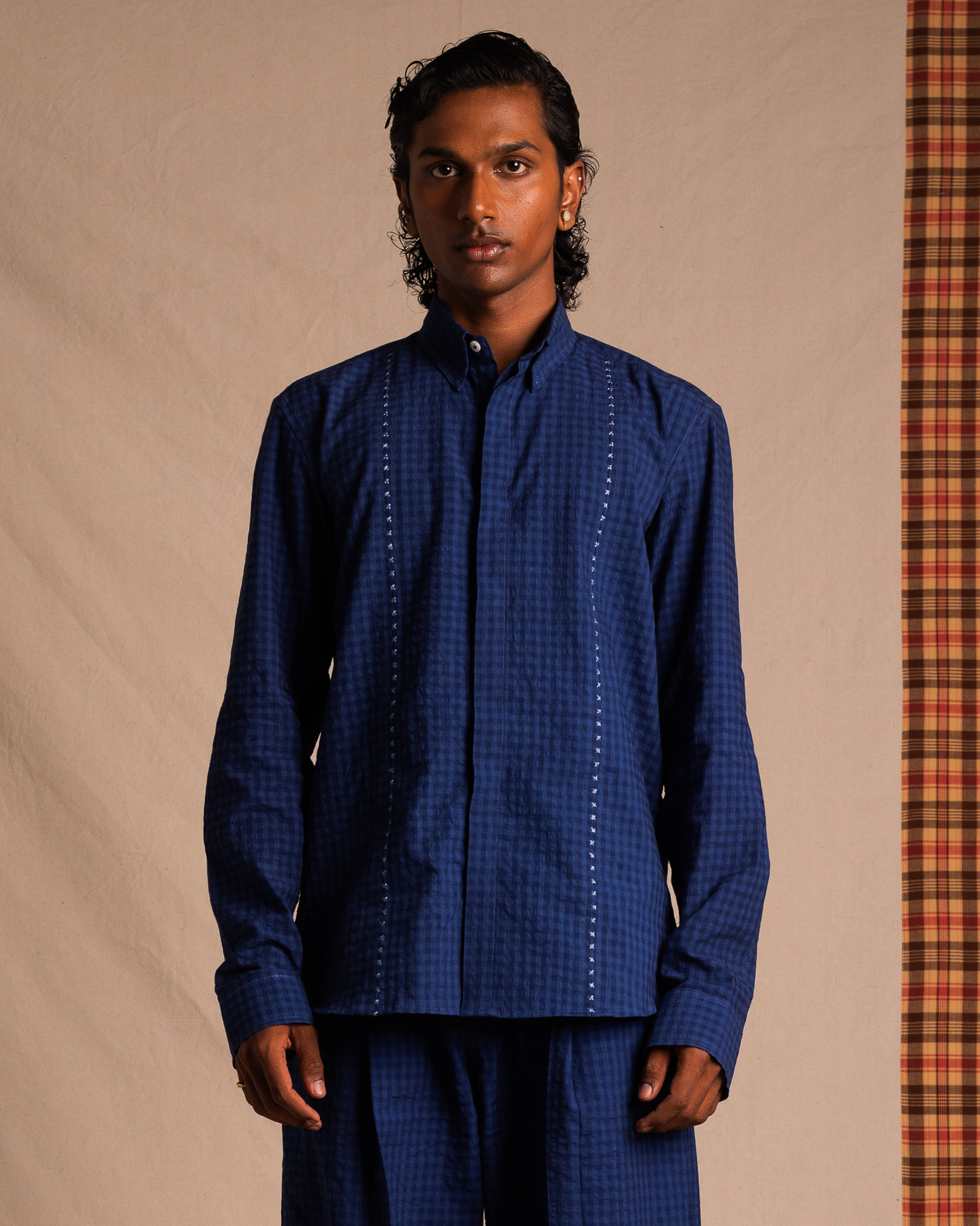 Man wearing a blue checkered long sleeve shirt and matching pants, streetwear style