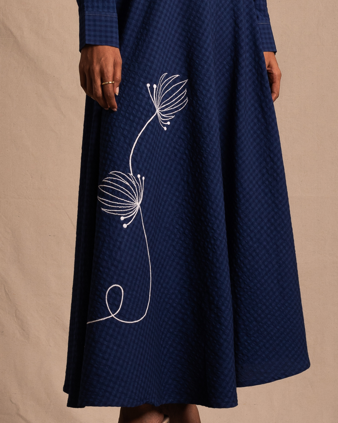 Blue textured midi skirt with white floral embroidery, streetwear style