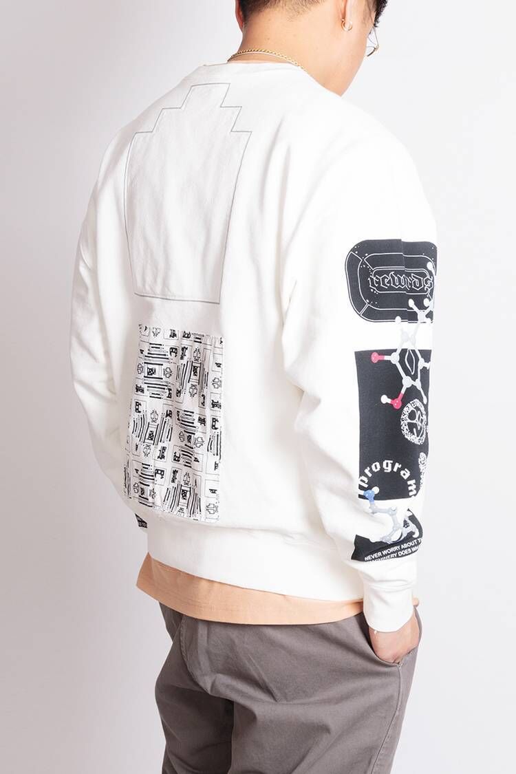Back view of man wearing white graphic streetwear sweatshirt with patchwork and science-inspired sleeve design