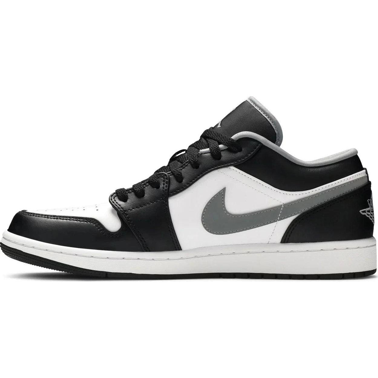 Low-top black, white, and grey sneaker with a grey swoosh and leather panels