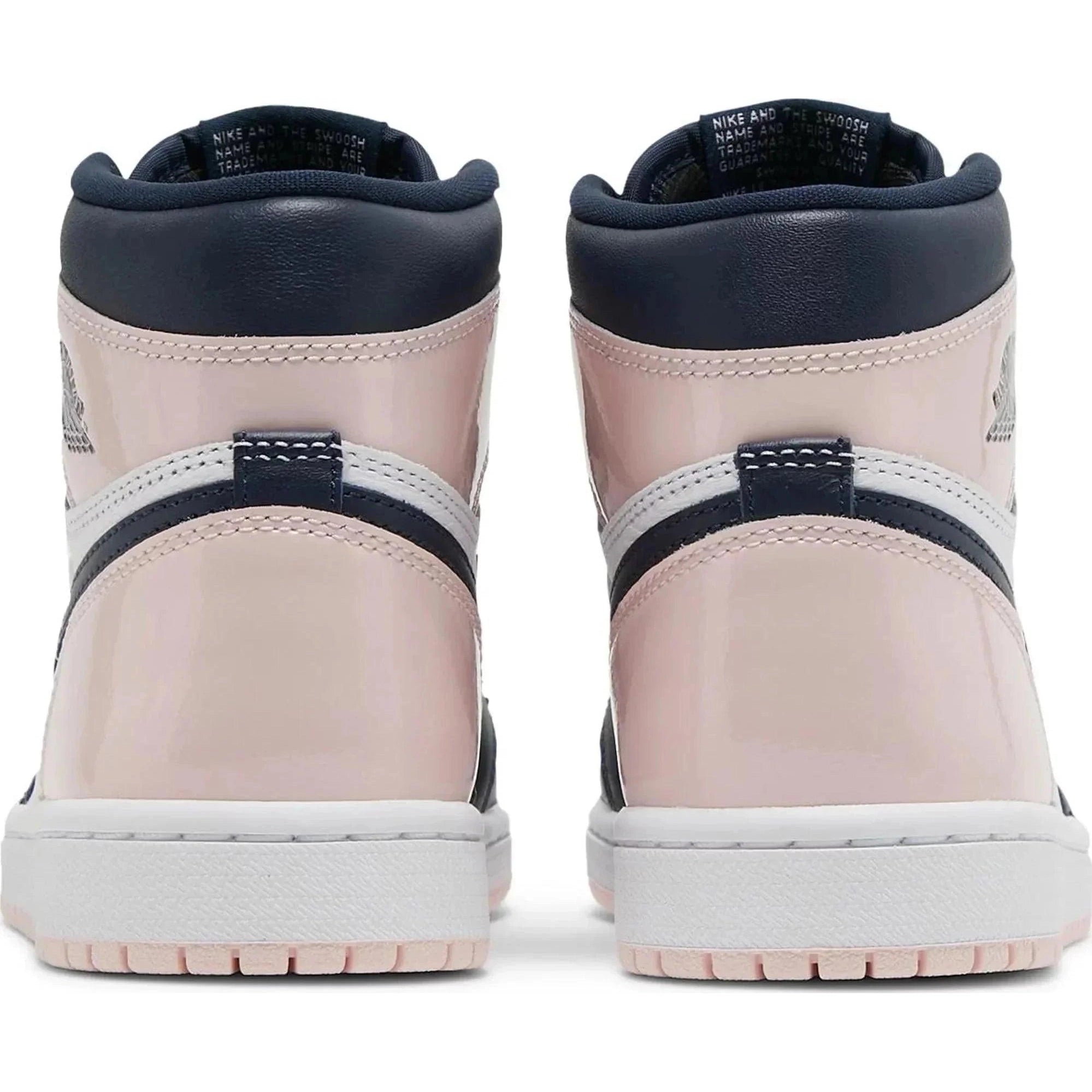 Back view of Air Jordan 1 Retro High OG SE sneakers in pink, navy, and white patent leather.