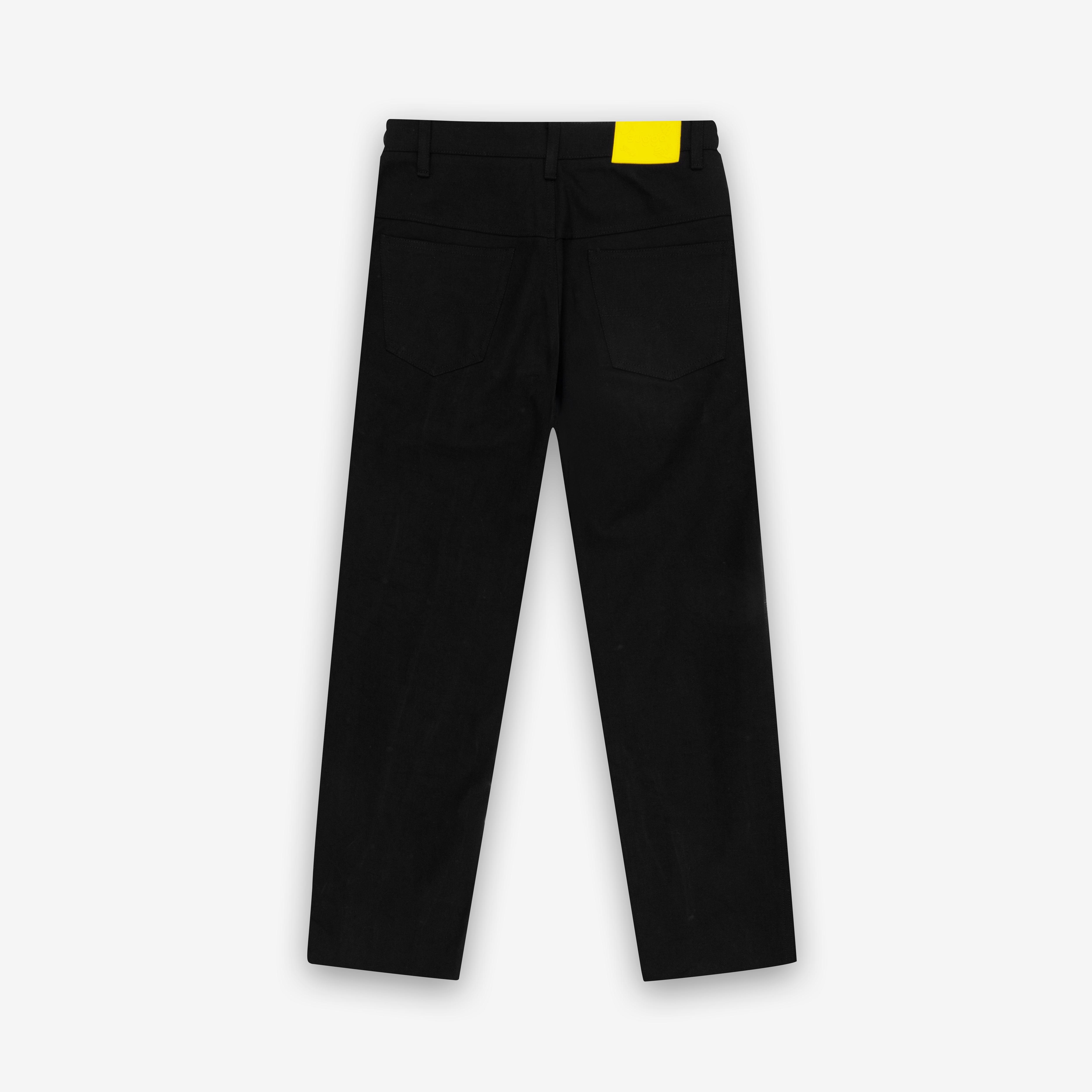 Back view of black jeans with two pockets and a yellow waist tag on plain background