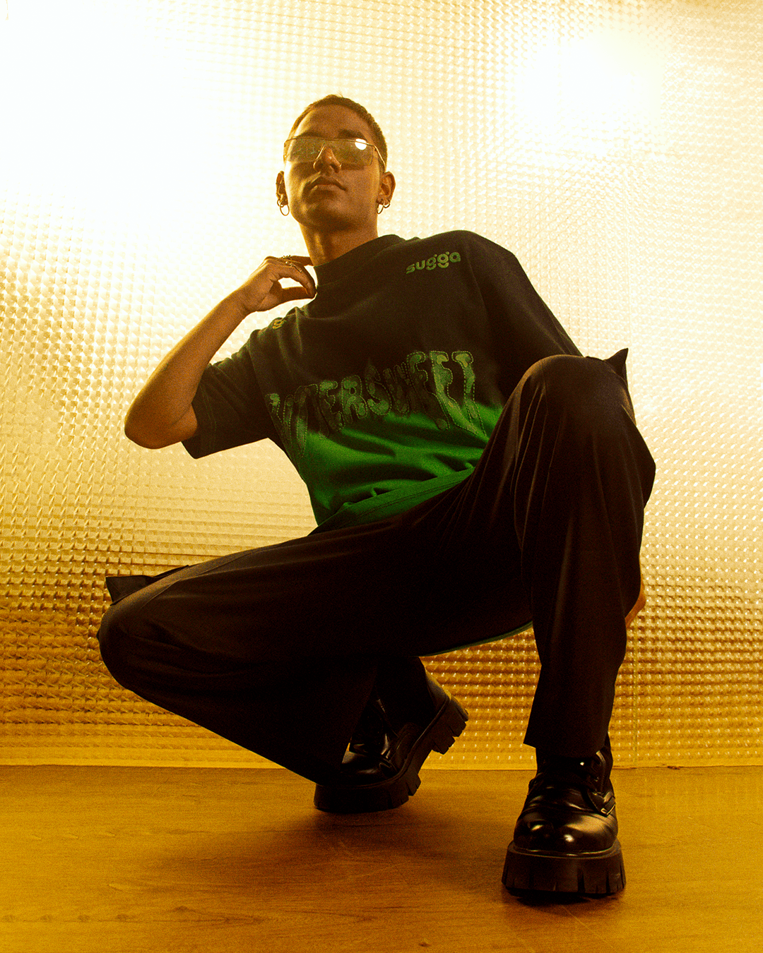 Model in trendy streetwear, green Bittersweet graphic tee, chunky black shoes, urban setting