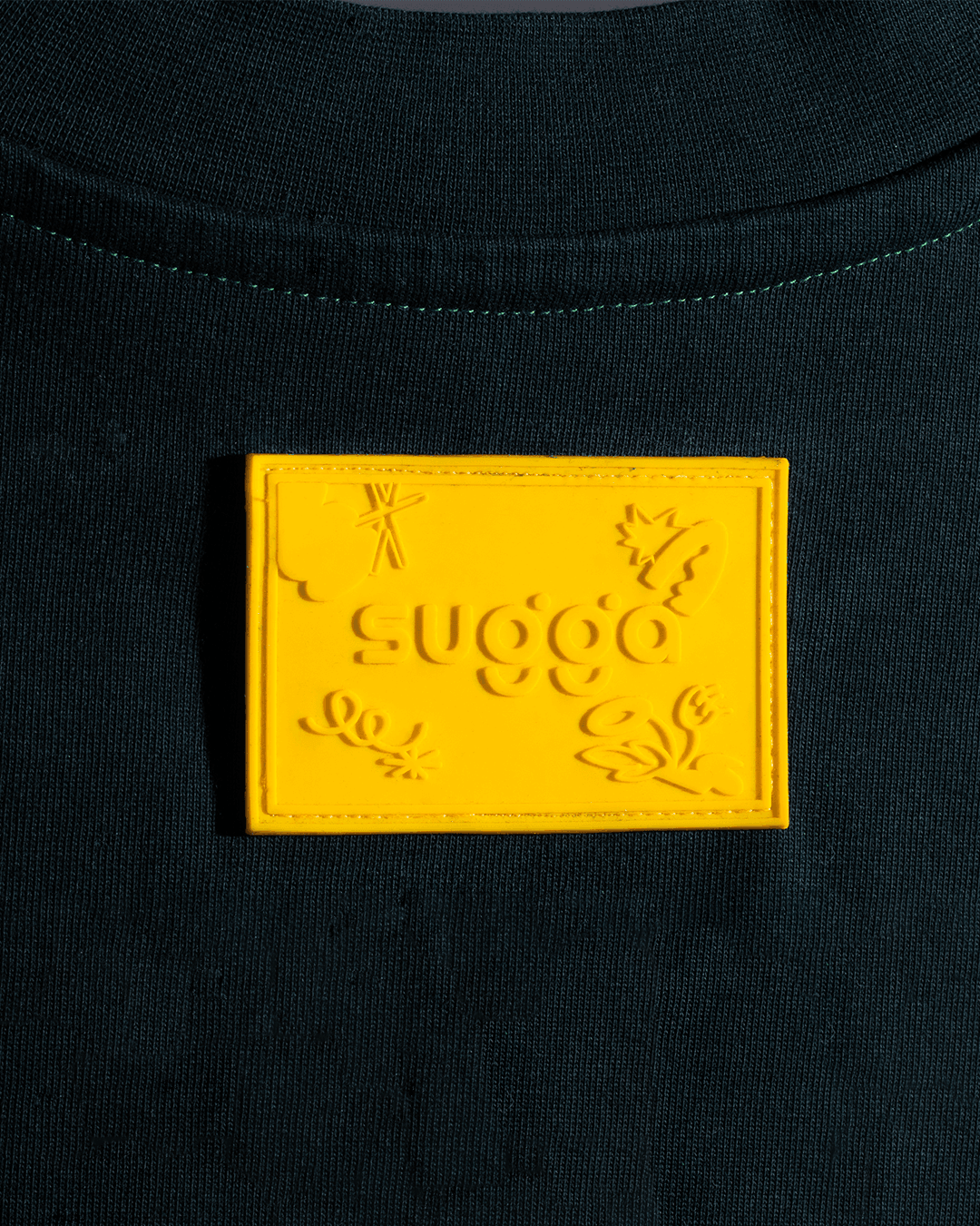Close-up of sweatshirt with yellow embossed patch and raised graphic details