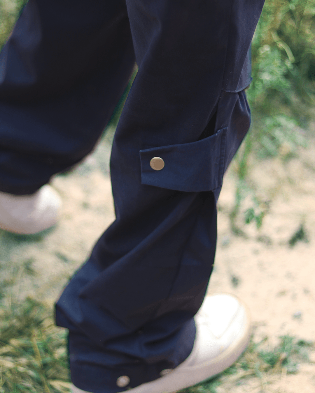 Navy cargo pants with side snap pocket and adjustable cuff, streetwear style