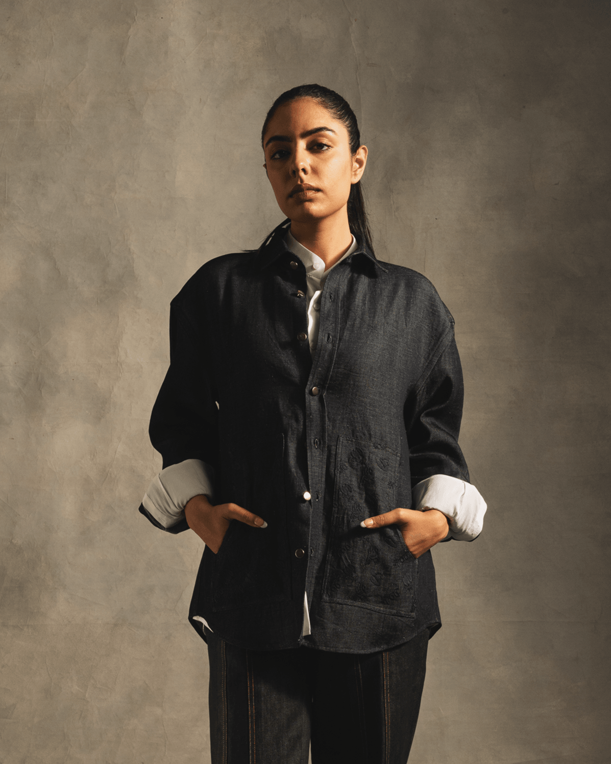 Woman wearing oversized blue denim shirt with front buttons and pockets, streetwear style