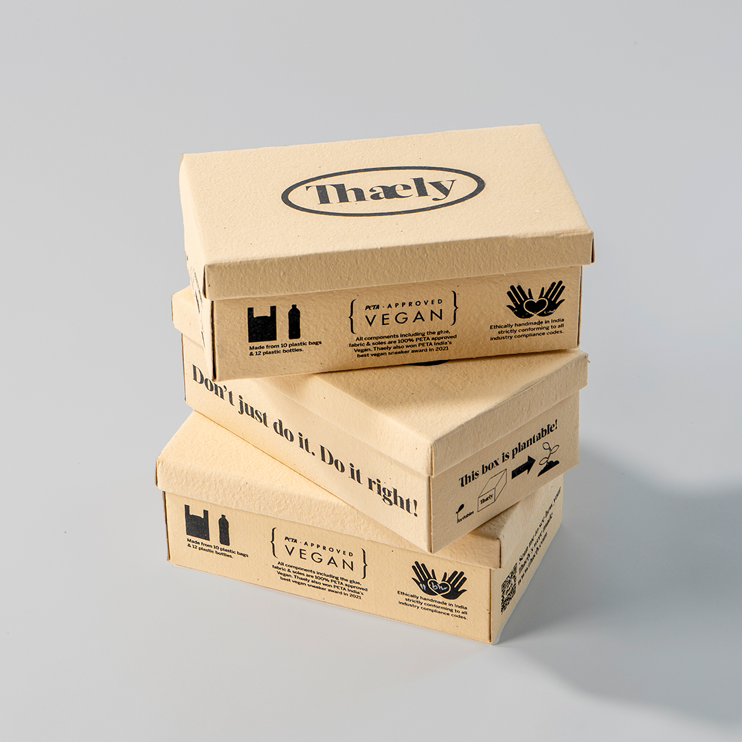 Stack of eco-friendly, vegan, plantable sneaker boxes with sustainability icons and labels