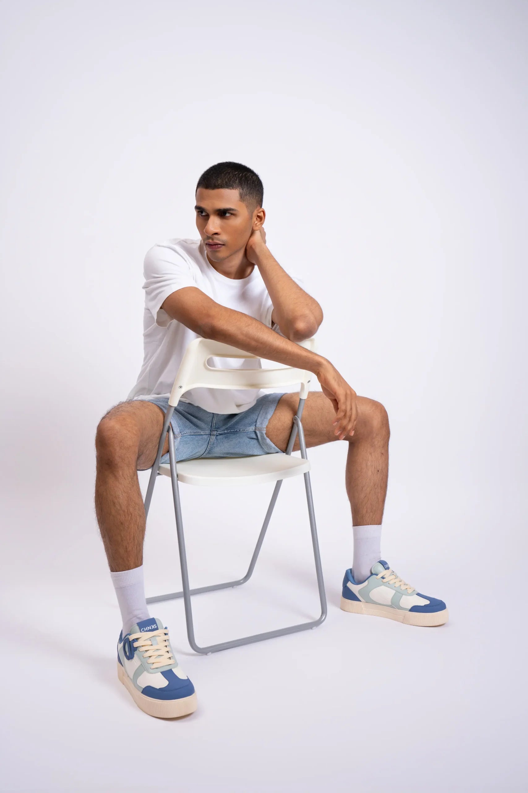Man wearing Atlantis CHNKS blue sneakers with white t-shirt and blue denim shorts – men’s casual sneaker style