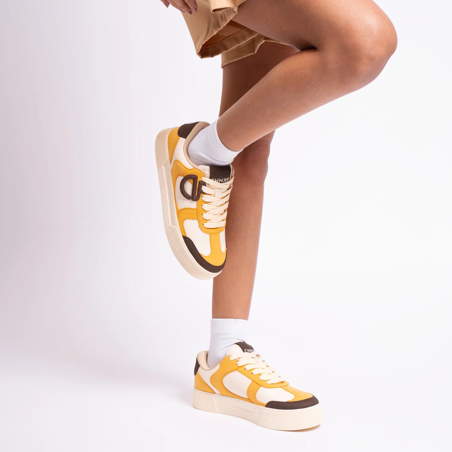 Buttercotch CHNKS sneakers on leg – women’s yellow sneakers for casual outfits