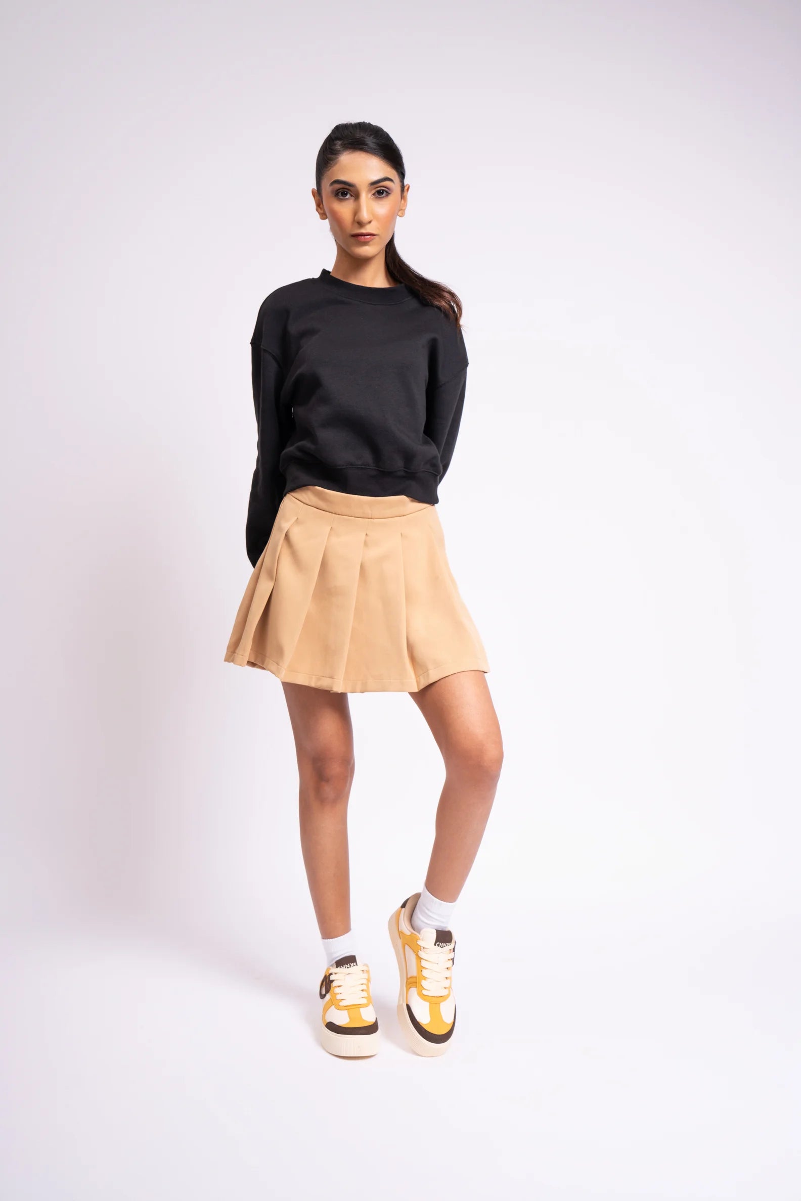 Model wearing Buttercotch CHNKS sneakers with black and brown outfit – women’s yellow street sneakers