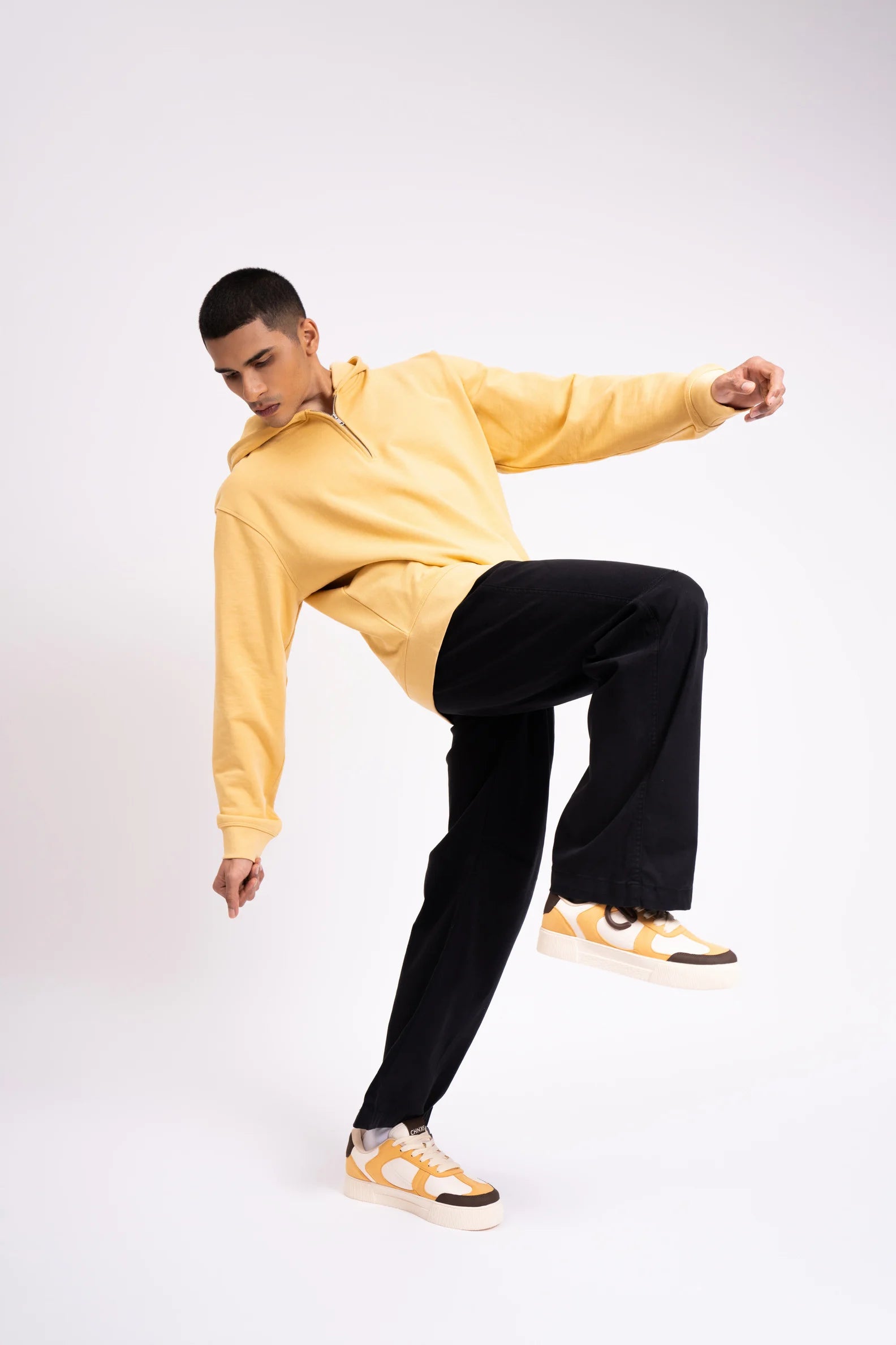 Model wearing Buttercotch CHNKS sneakers with yellow t-shirt and black trouser – men’s yellow sneakers