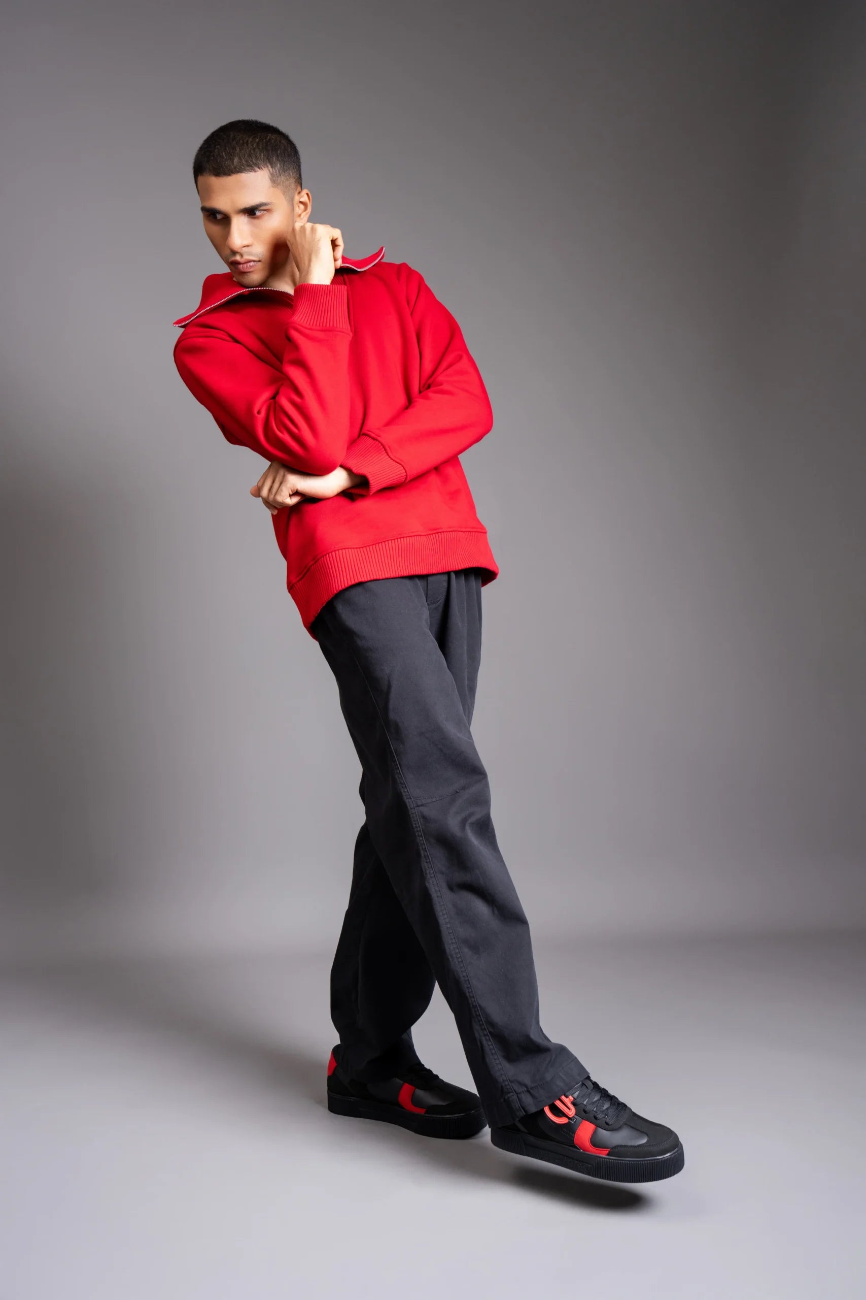Model wearing Vinyl CHNKS sneakers with red t-shirt and black trouser – men’s streetwear look