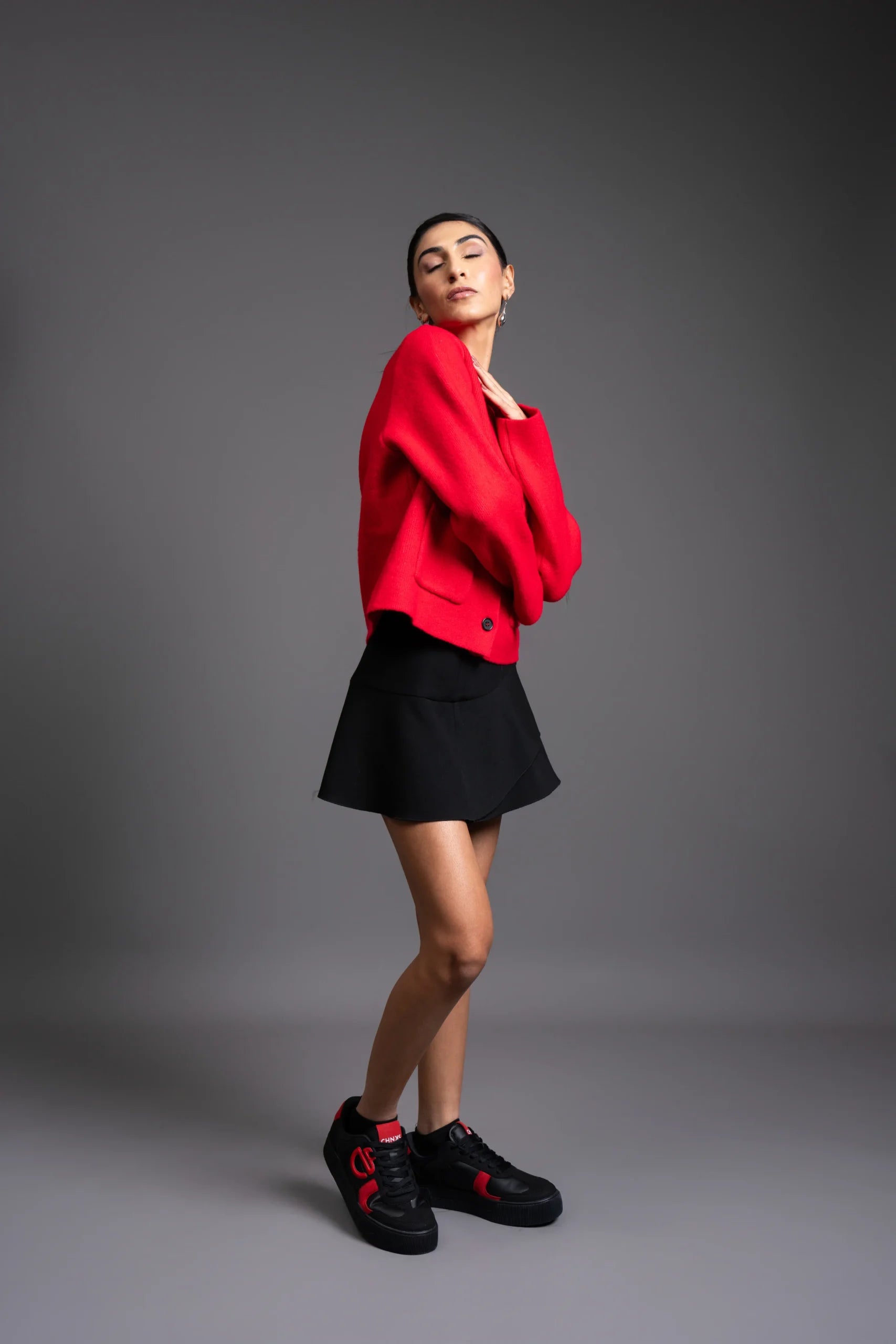 Model wearing Vinyl CHNKS sneakers with red and black outfit – women’s fashion look