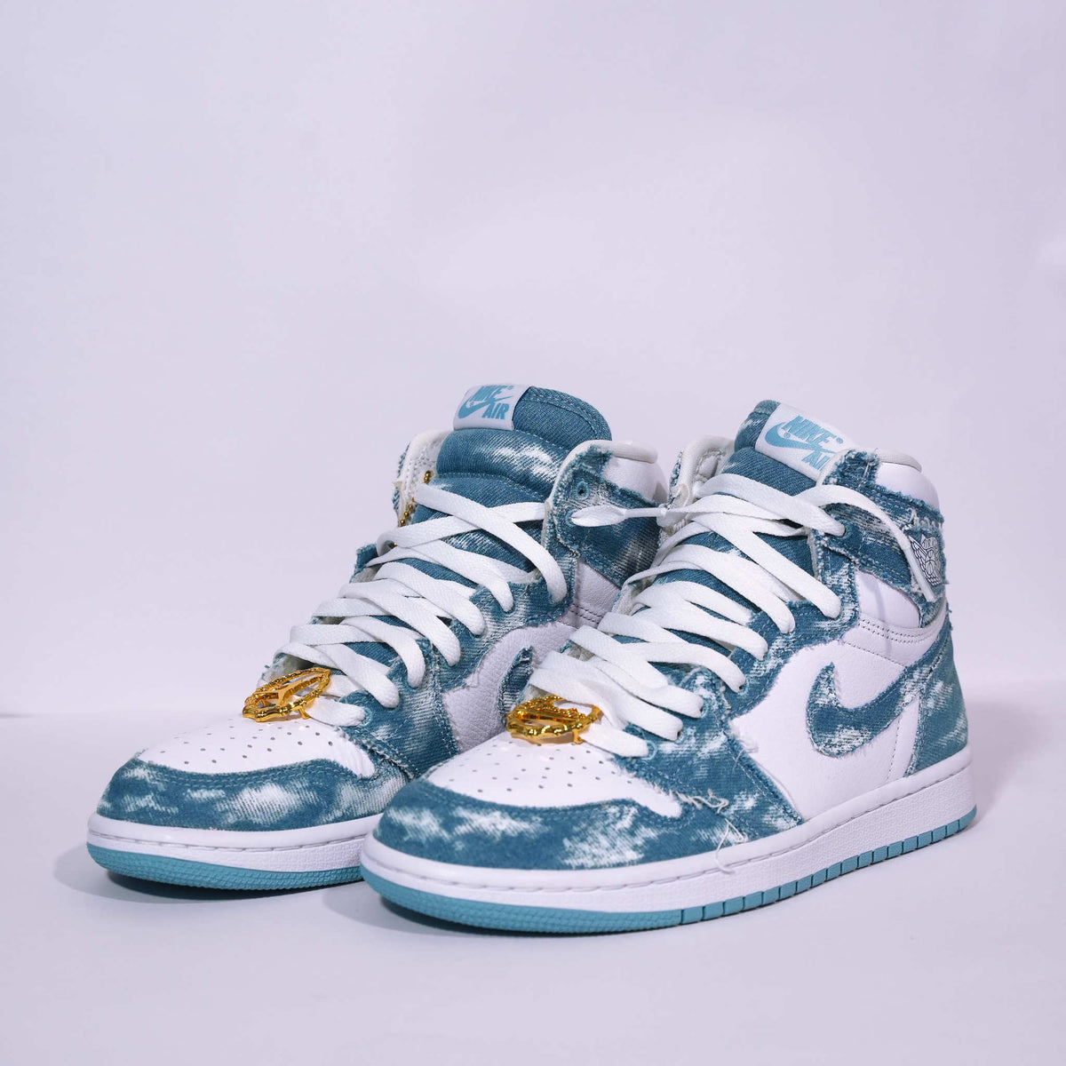 Blue and white distressed high-top sneakers with gold lace charms and white laces